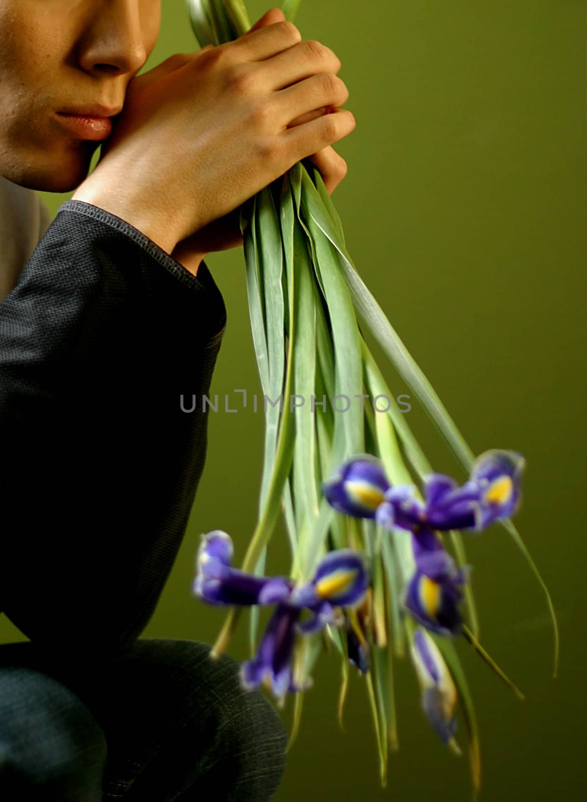 Young the man with a bouquet of irises in hands