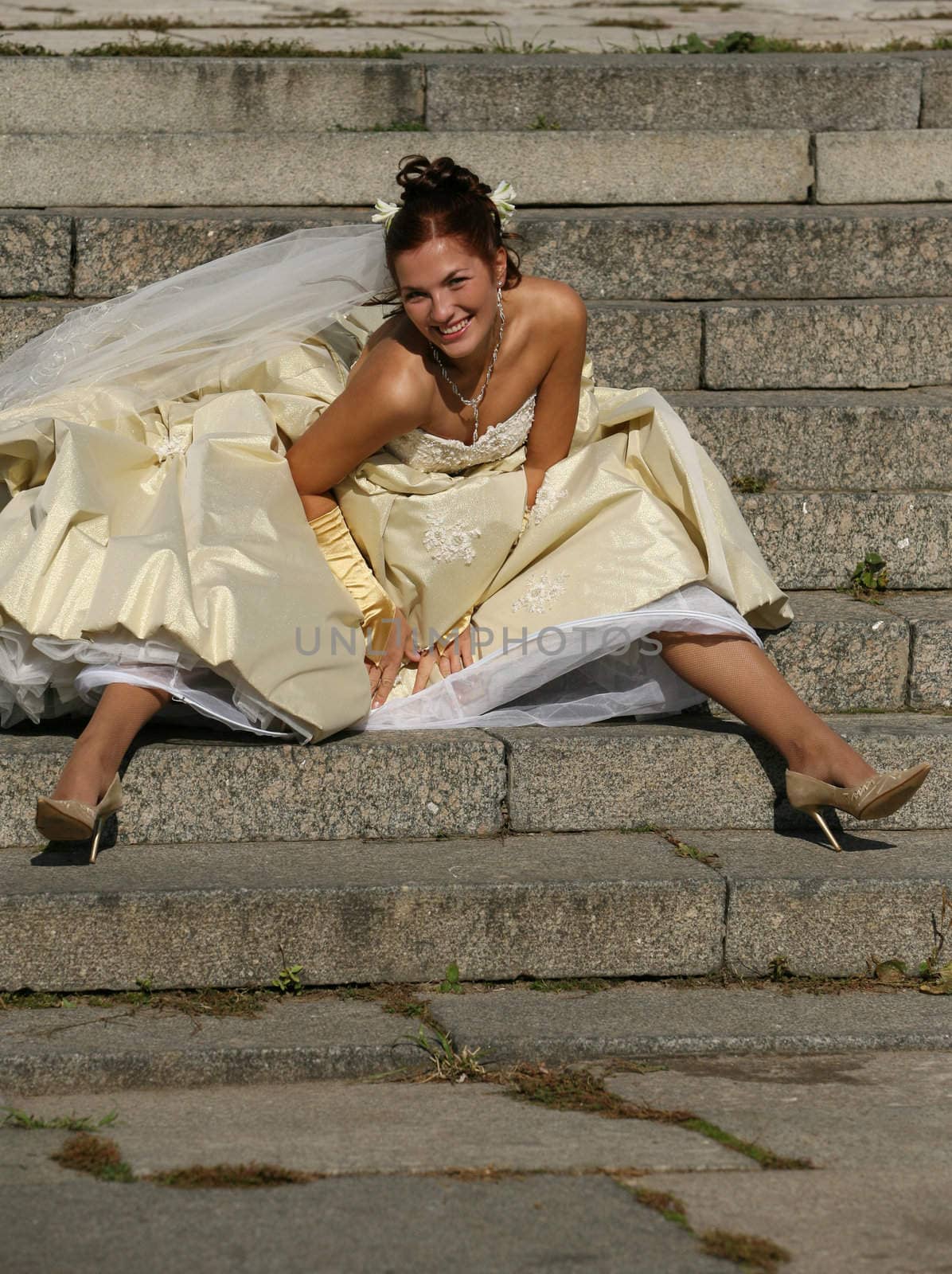 The beautiful bride sitting on a stone ladder