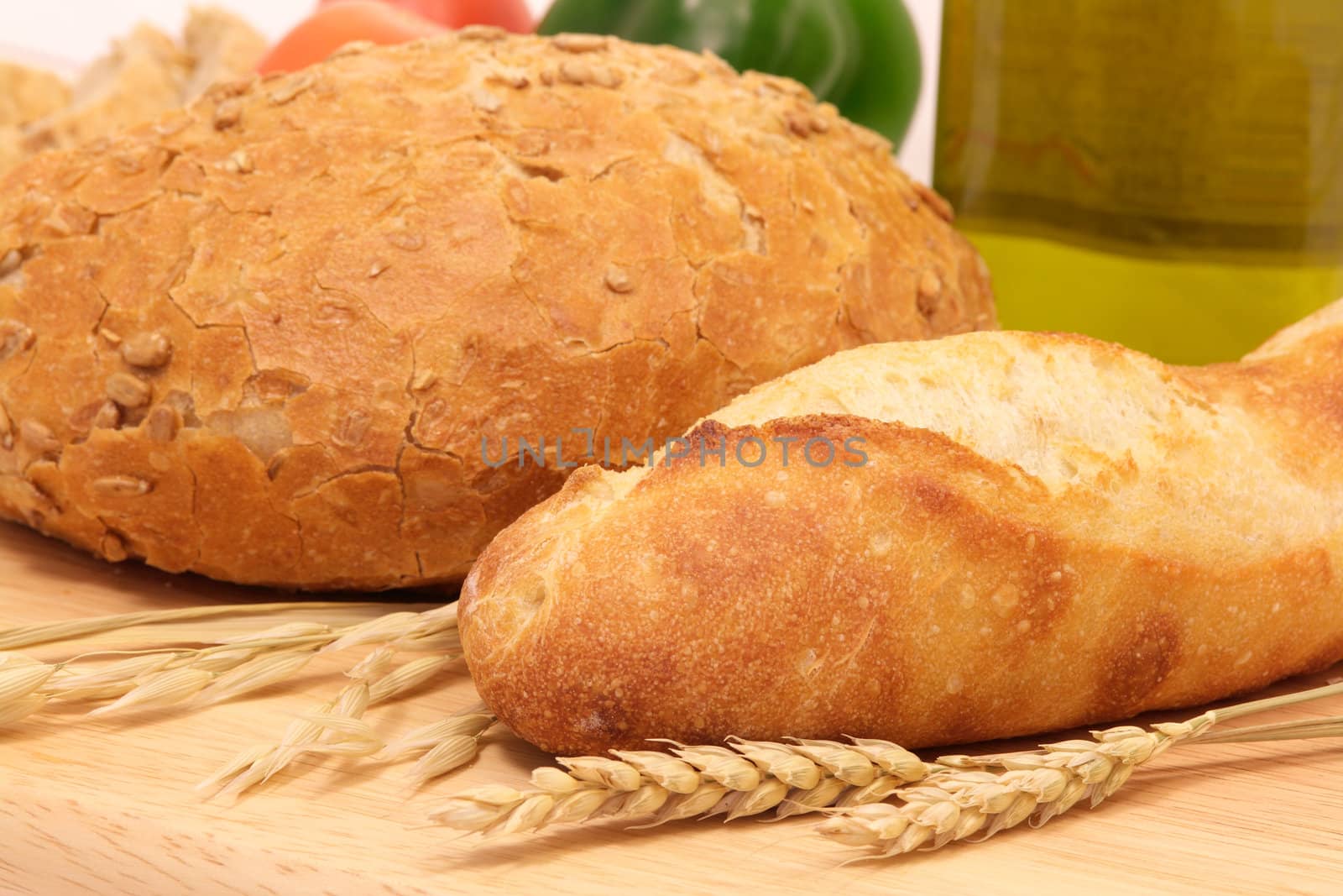 Breads on wood with wheat ears and oat, on a mediterranean background