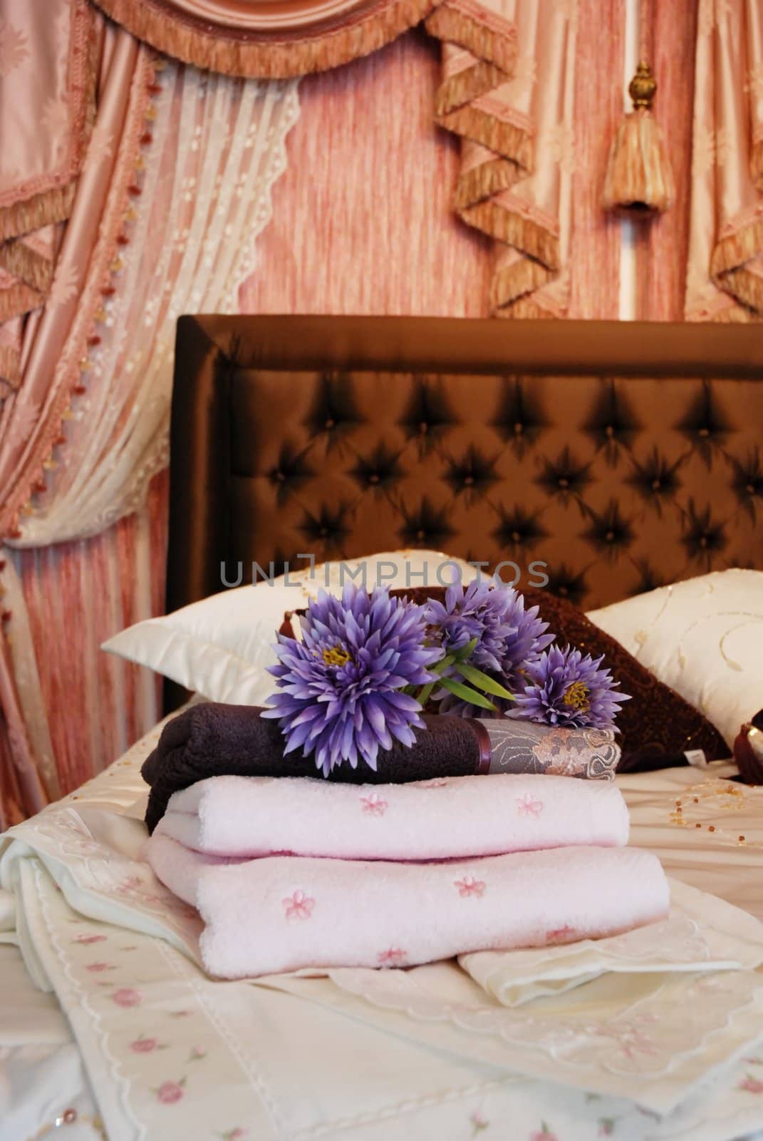 Folded towels ready for use set out on a hotel room bed.