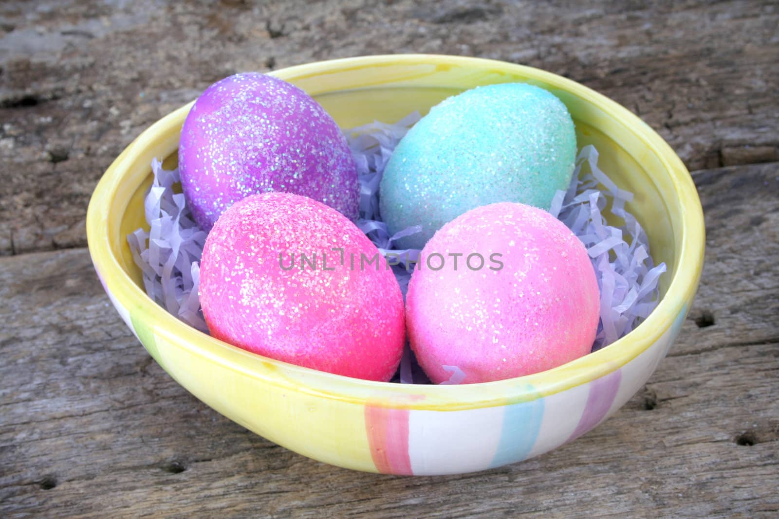 Egg shaped dish holding colorful Easter eggs.