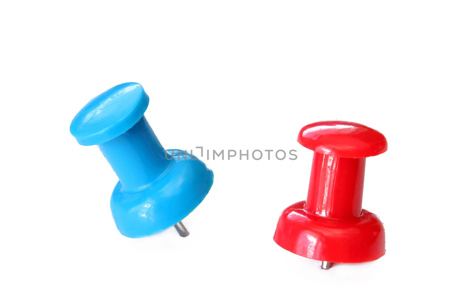 Two push pins of red and blue on a white background.