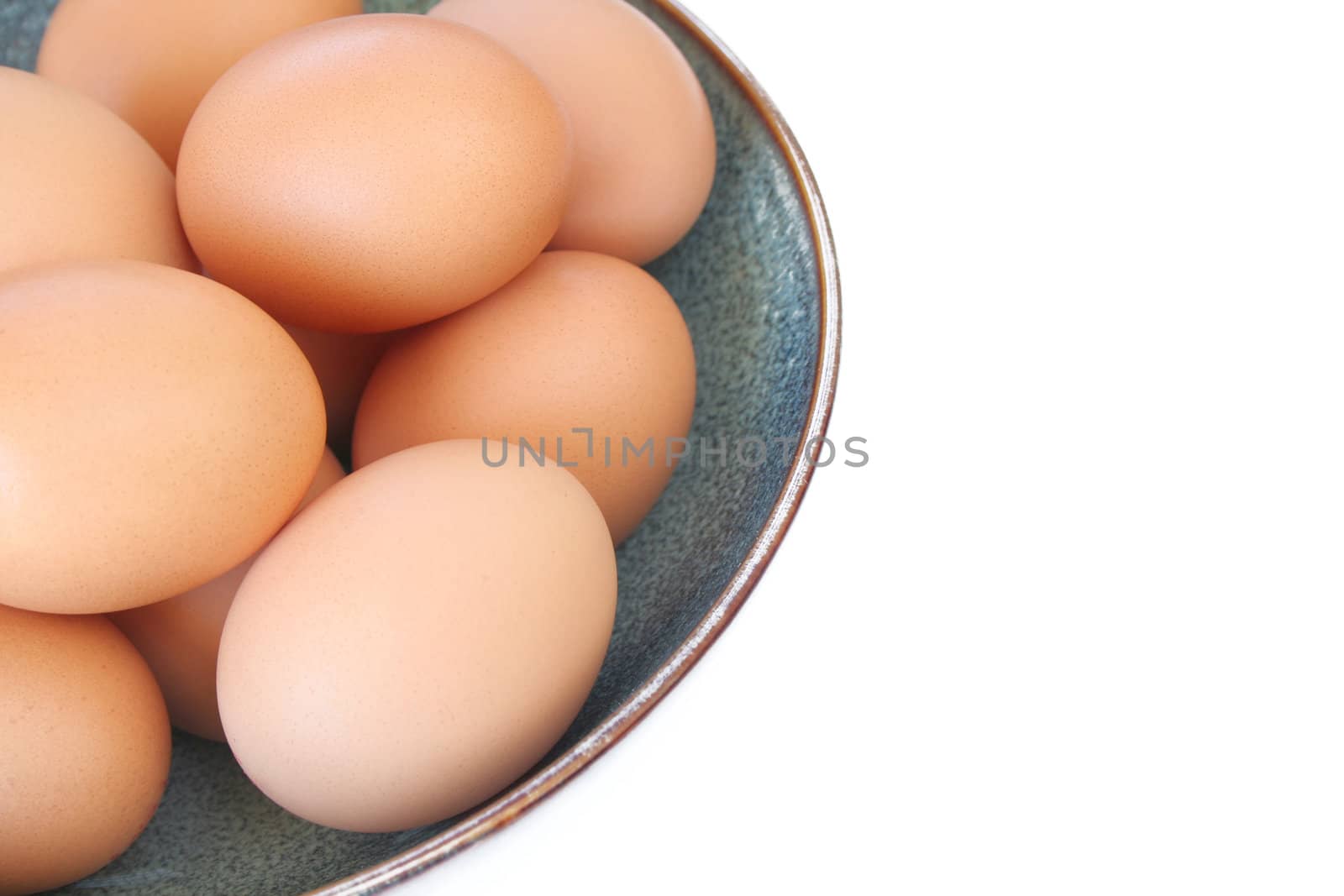 Bowl of organic eggs isolated on a white background with room for copy space.