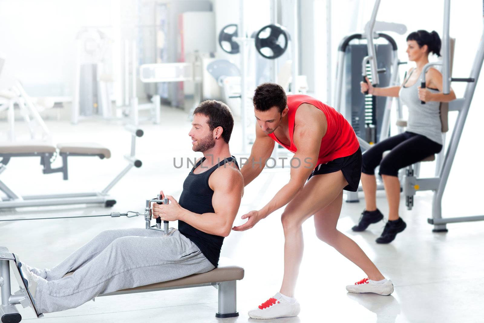 man in gym with personal trainer and fitness woman