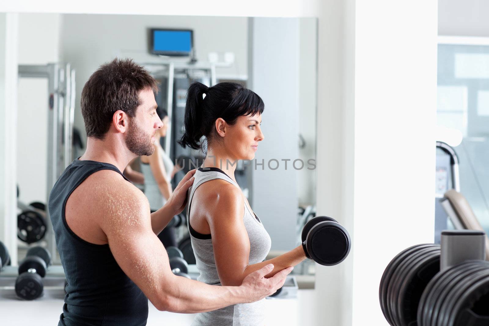 gym woman personal trainer with weight training by lunamarina