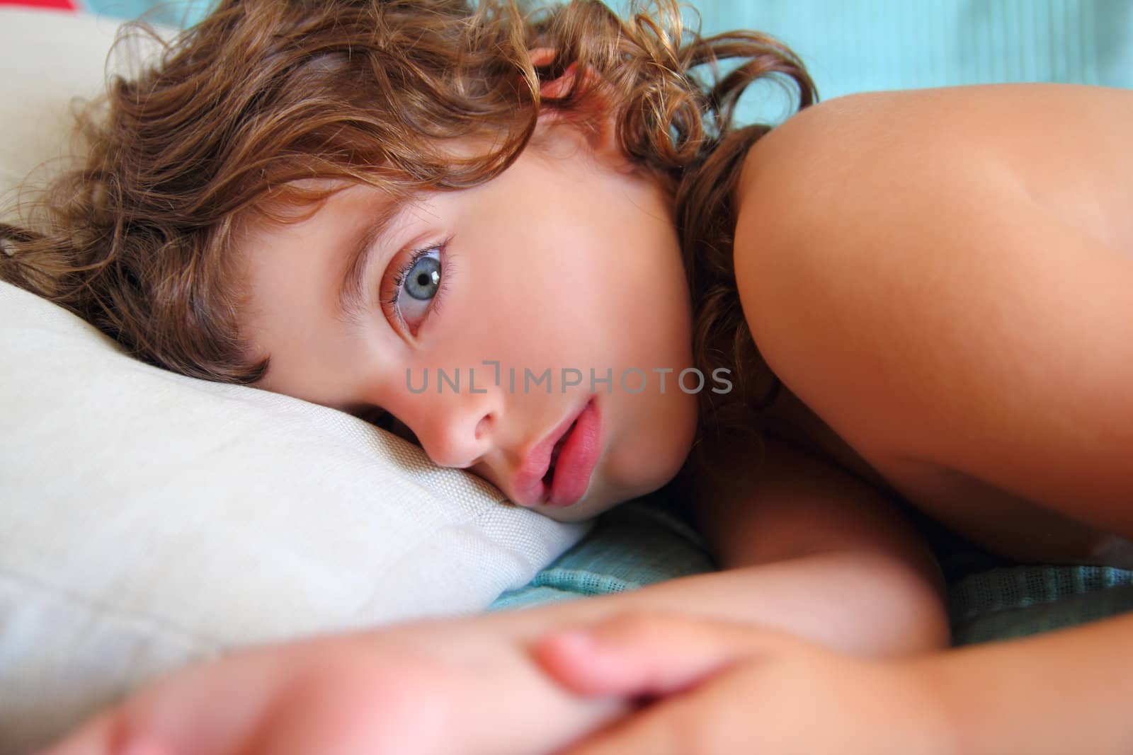 child girl relaxed on pillow looking camera with blue eyes