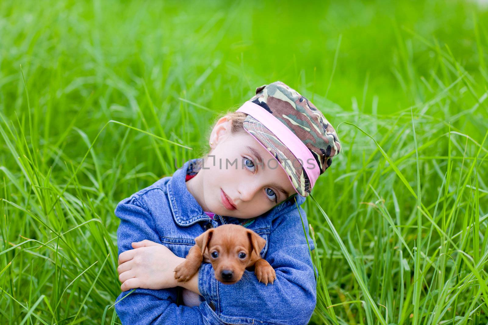 little girl with pet puppy mascot mini pinscher in outdoor green grass