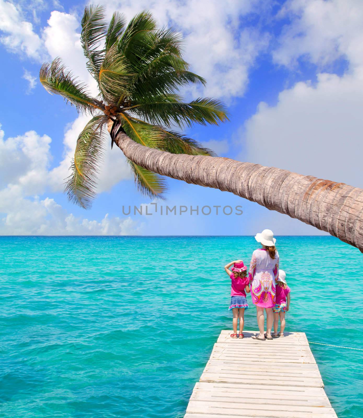 Daughters and mother in jetty on tropical beach by lunamarina