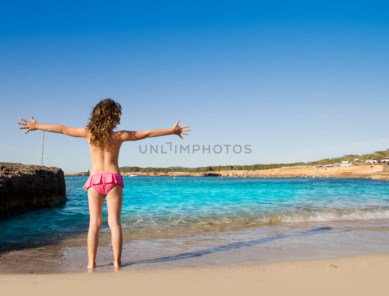 Ibiza Cala Conta beach open arms little girl happy in summer vacation