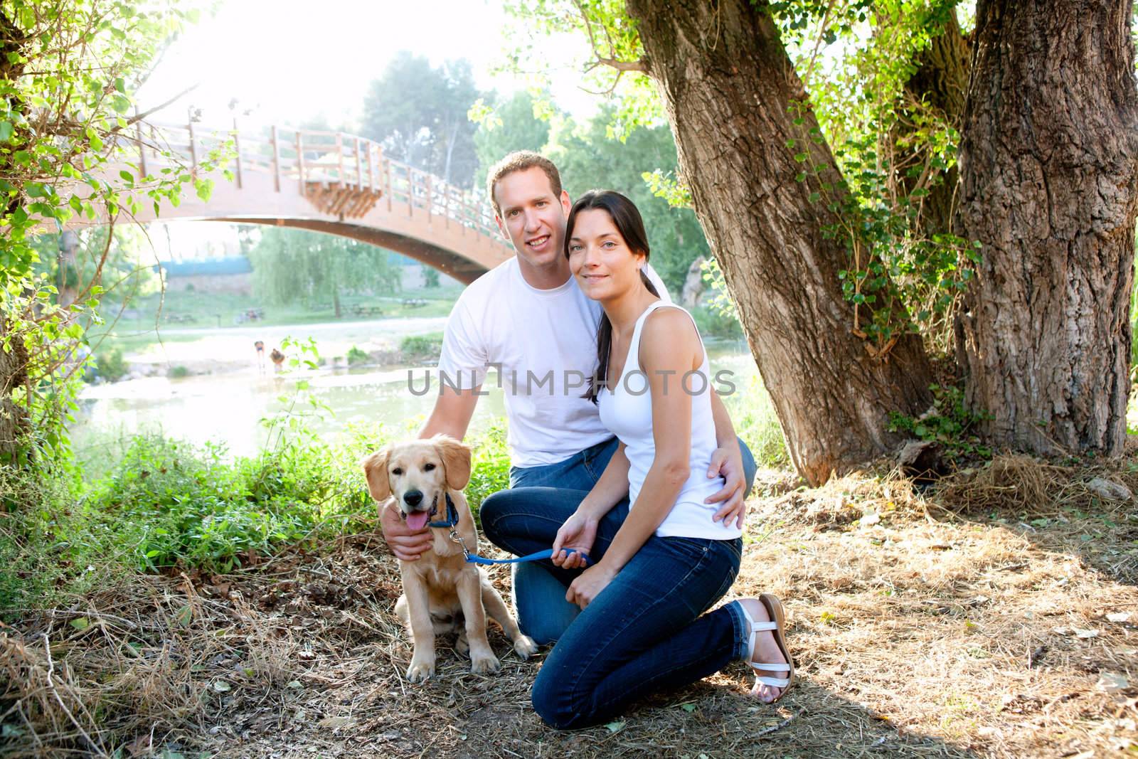 Couple in love with dog in outdoor river with bridge