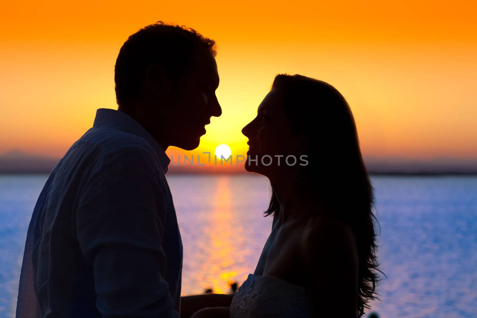 couple sunset profile back light in orange sea lake