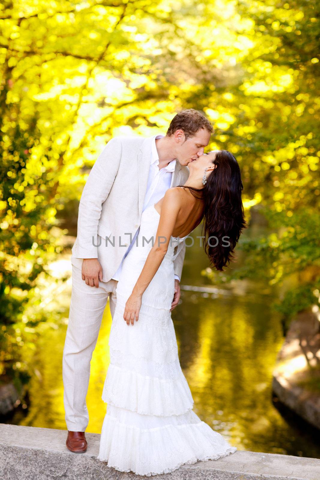 couple kissing in honeymoon outdoor park by lunamarina