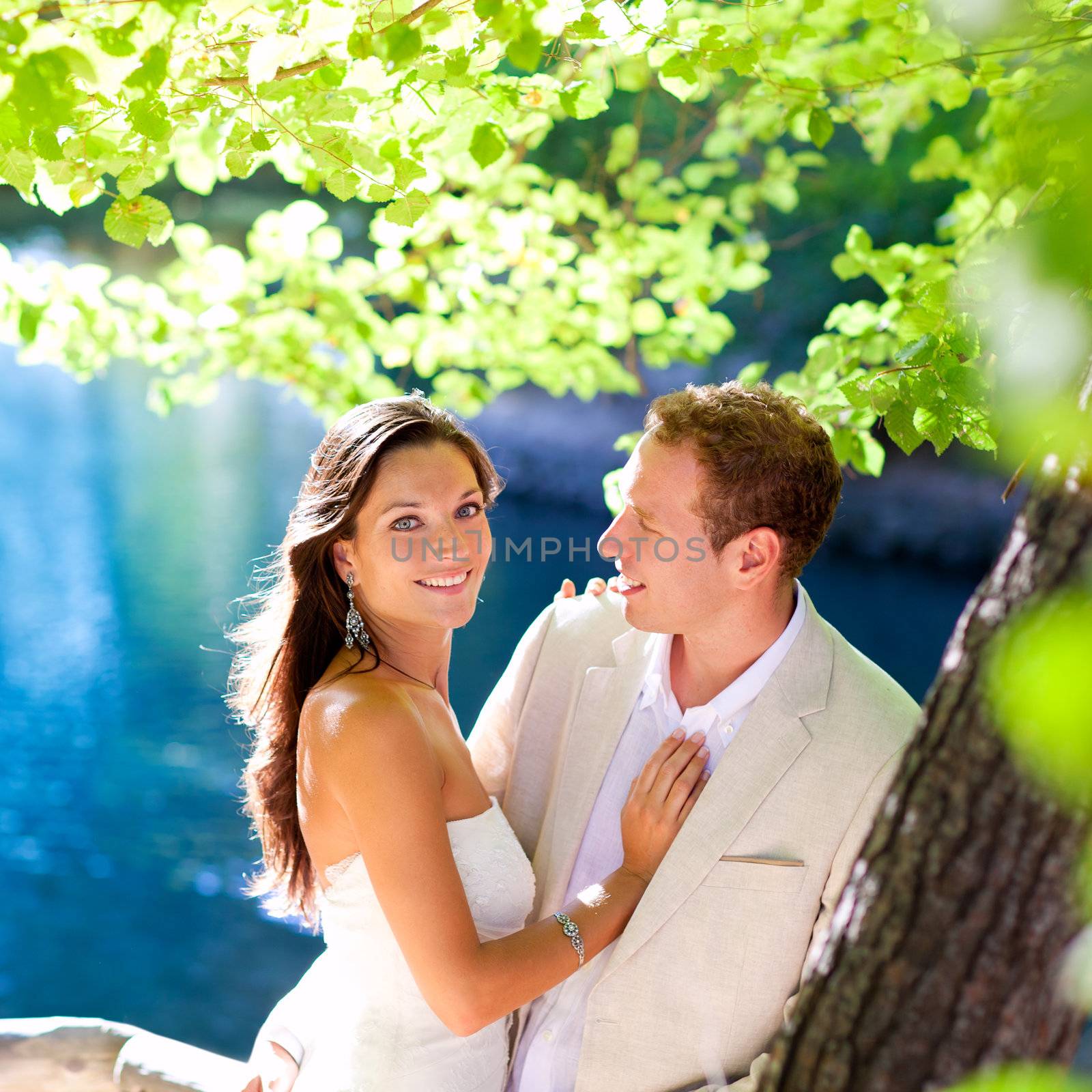 couple in love hug in forest tree blue lake outdoors