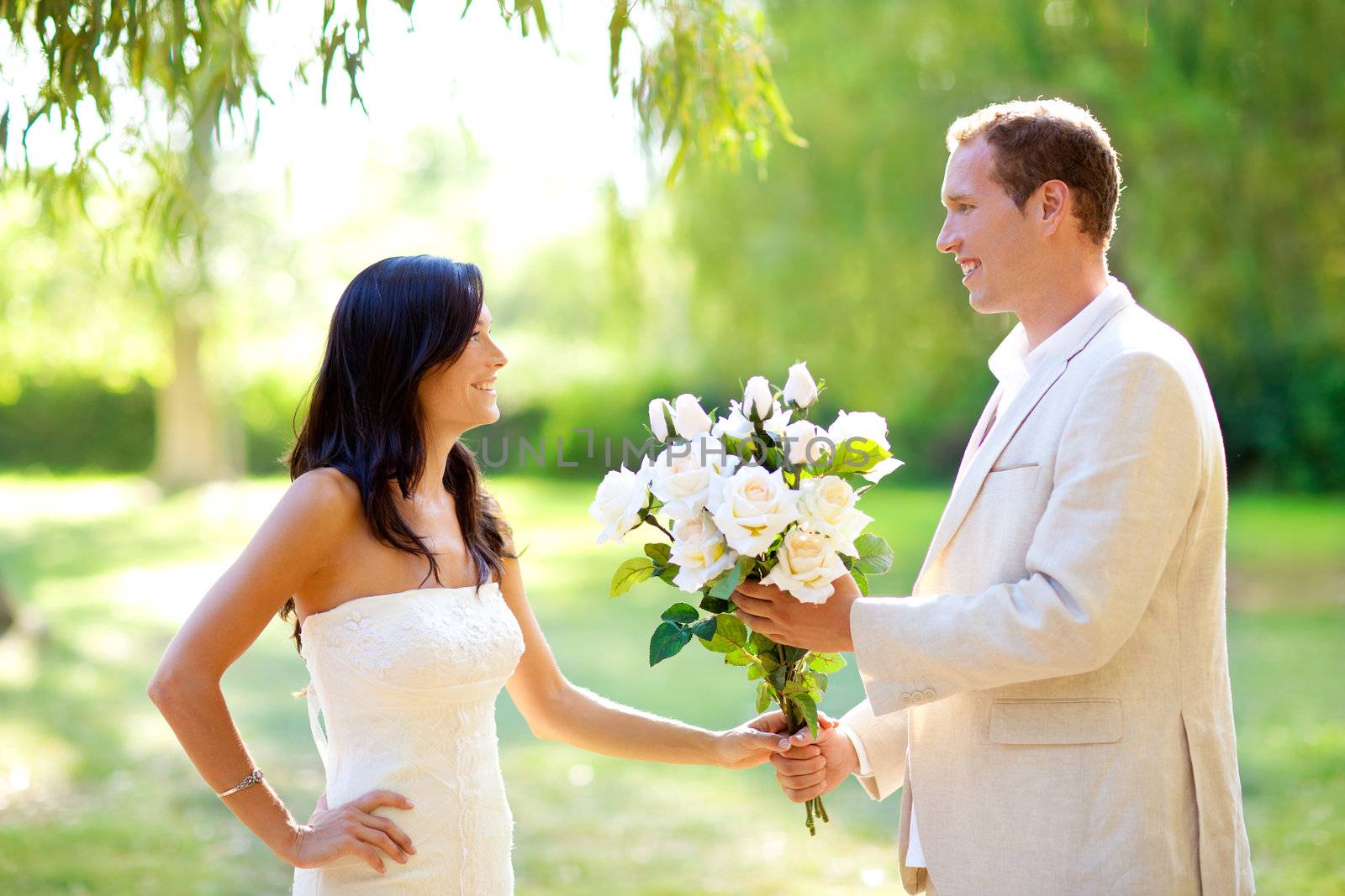 couple just married with man holding flowers by lunamarina
