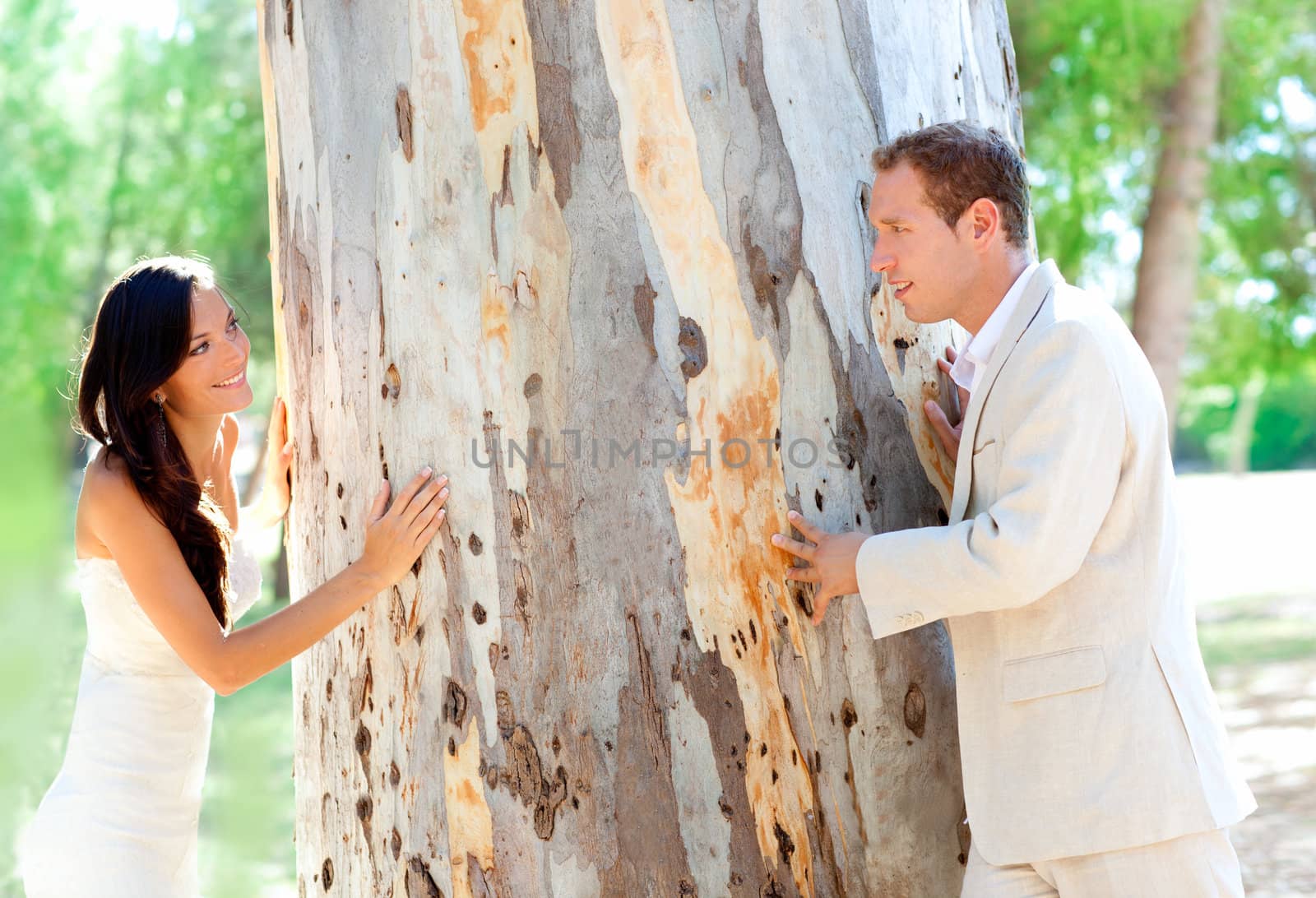 Couple happy in love playing in a tree trunk outdoor park