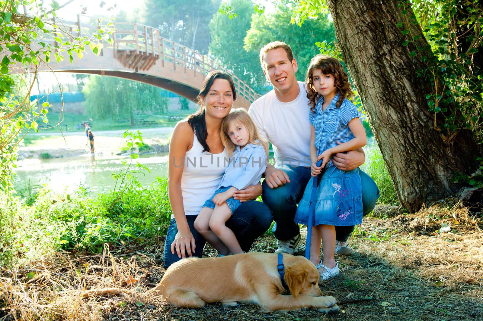 Happy family father mother kids and dog outdoor river park