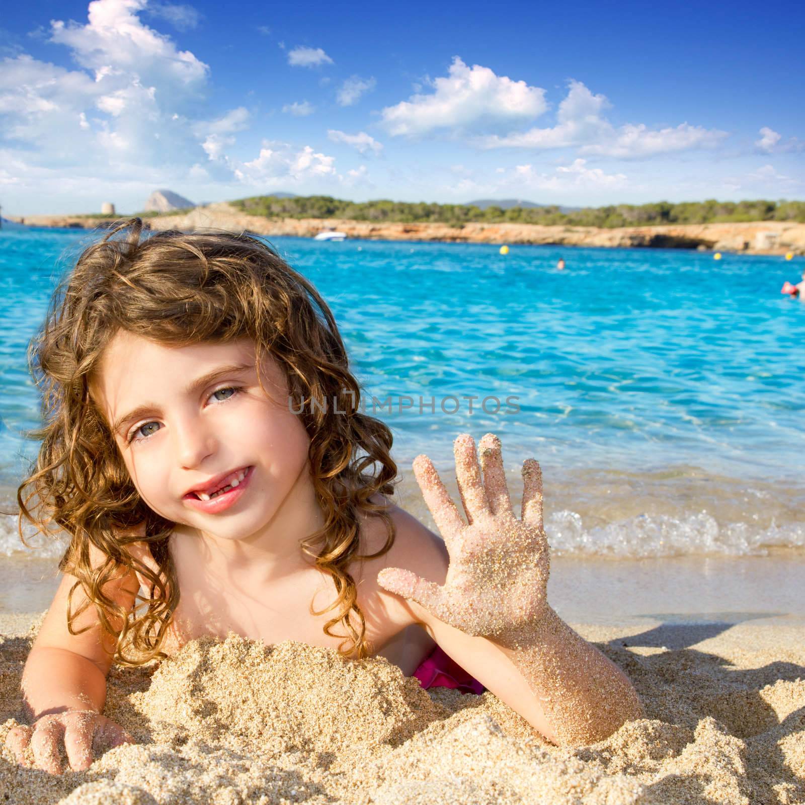 Little girl greeting hand gesture in sandy beach of Ibiza Cala Conta