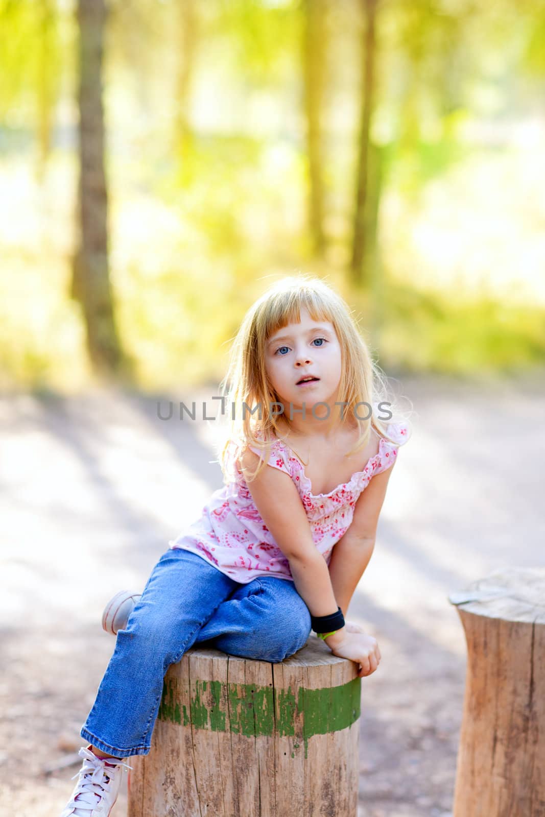 blond kid girl in tree trunk forest outdoor