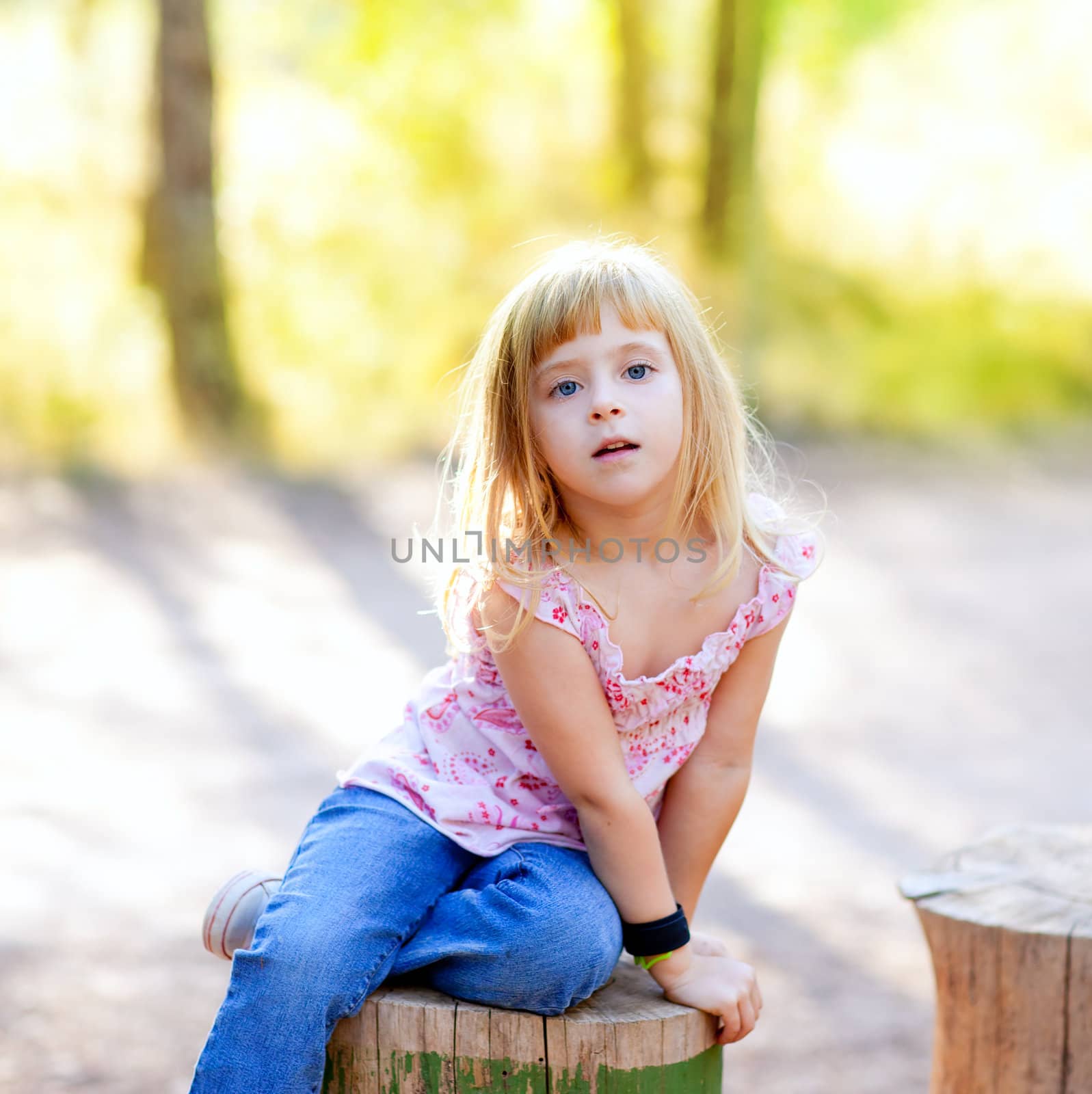 blond kid girl in tree trunk forest outdoor