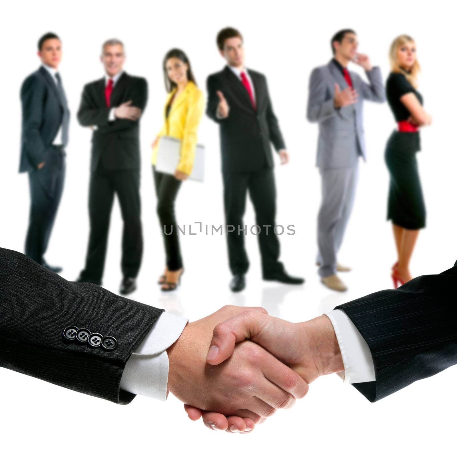 business people handshake with company team in background