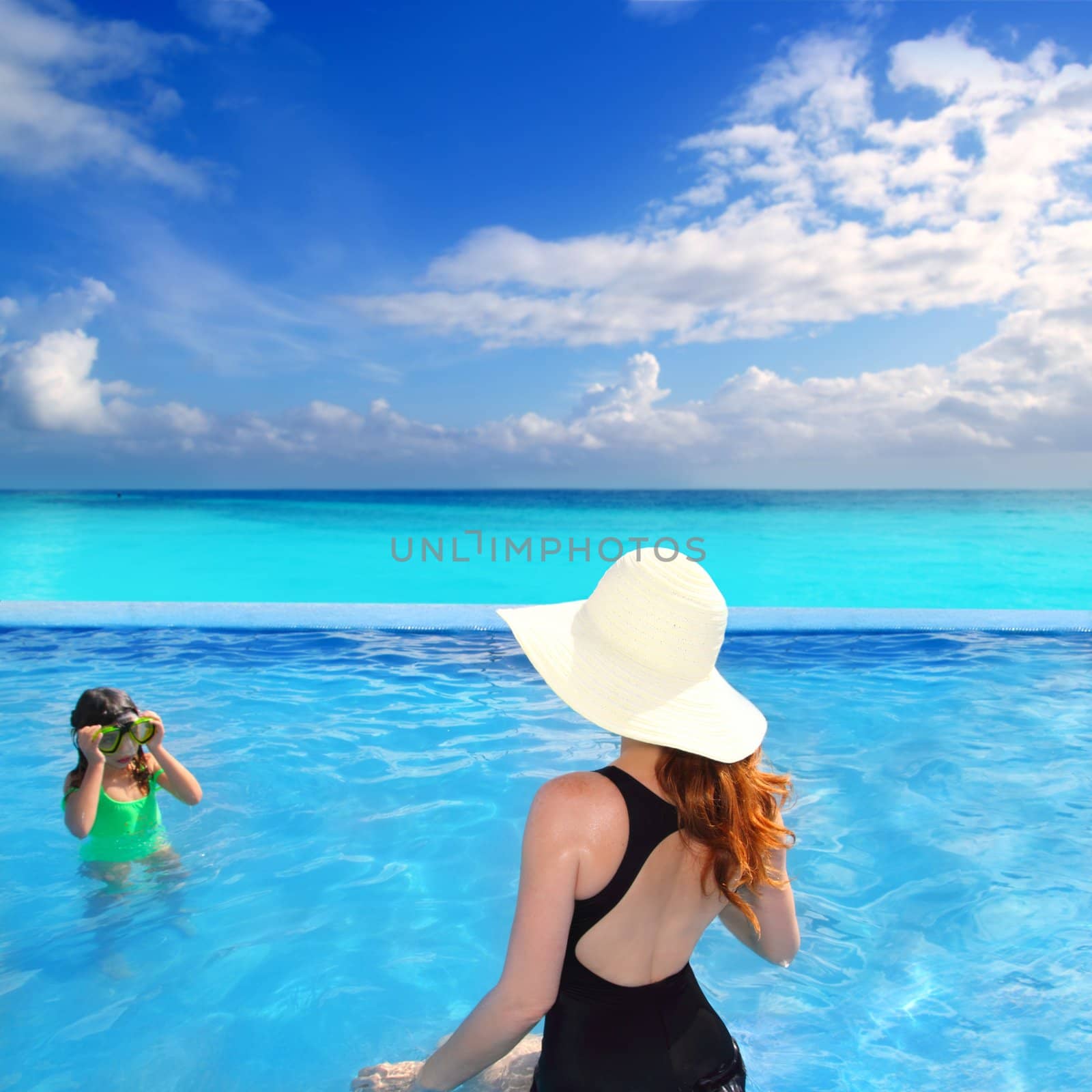 blue swimming pool with direct caribbean view rear motherview and goggles daughter in background