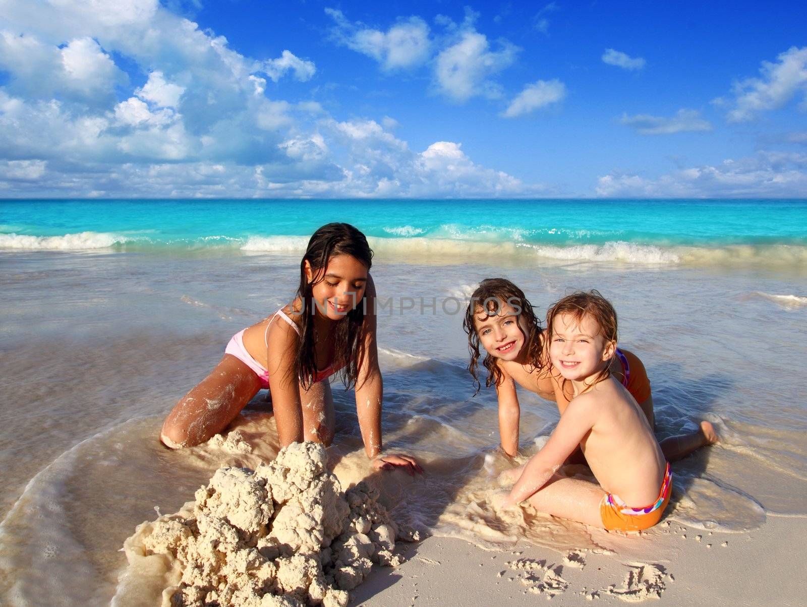 three little girls mixed ethnicity playing beach by lunamarina