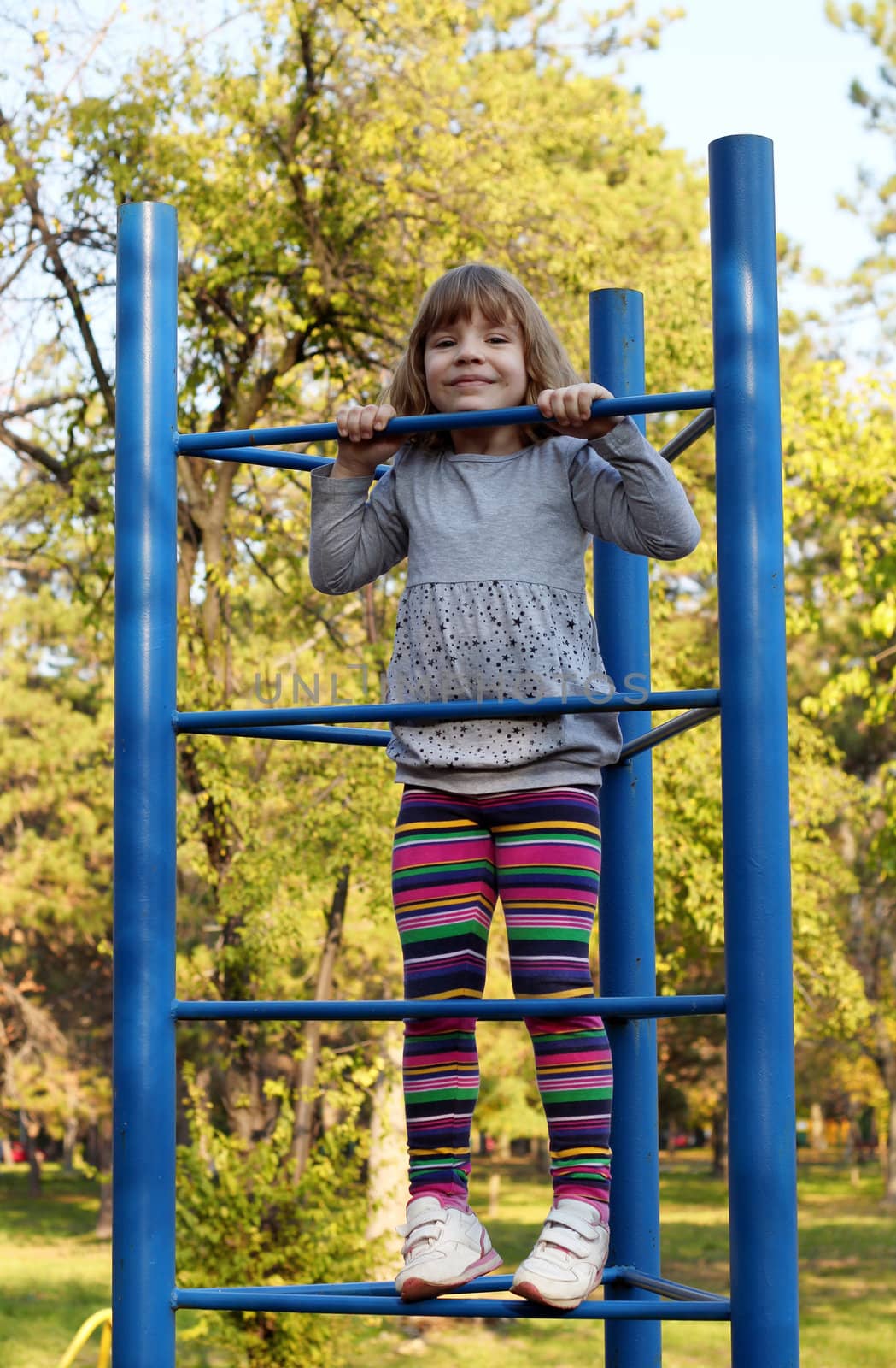 little girl climb on park playground
