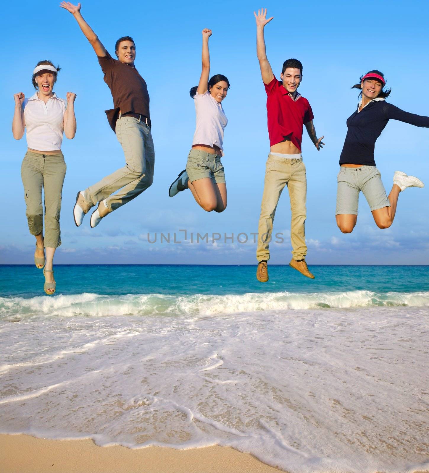 Jumping young people happy group tropical beach by lunamarina