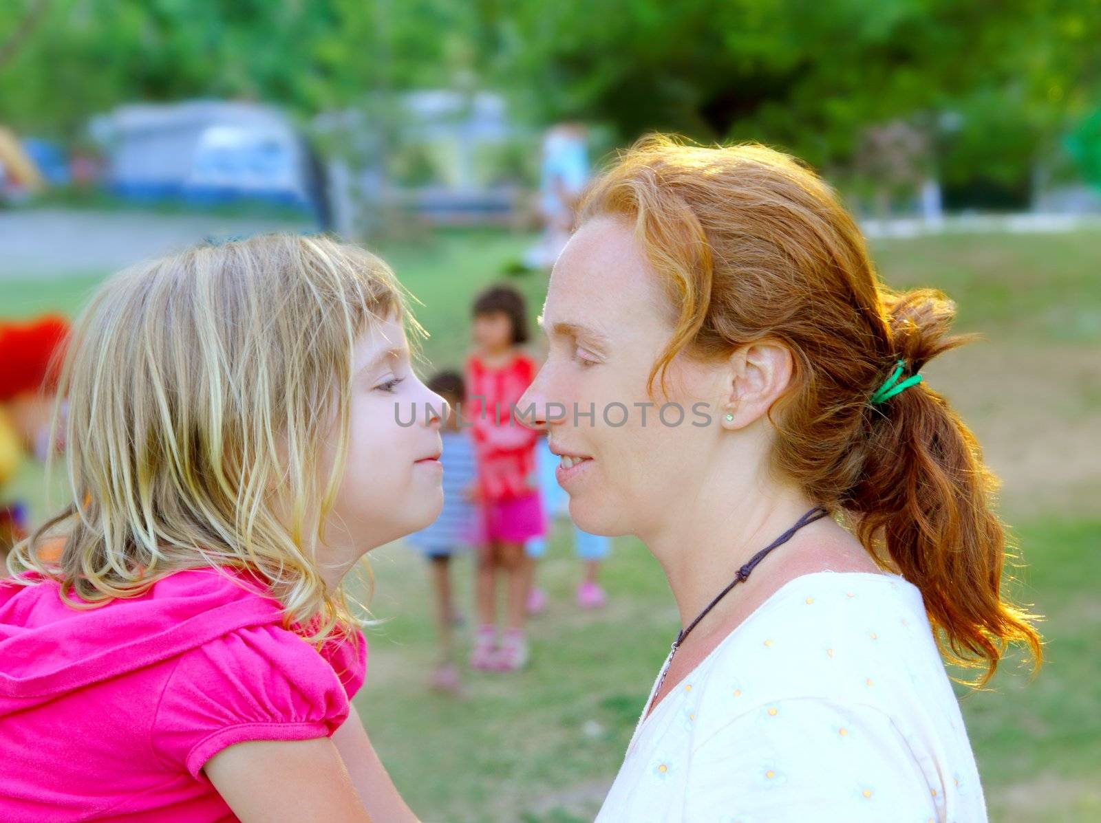 Mother and daughter profile playing in park by lunamarina
