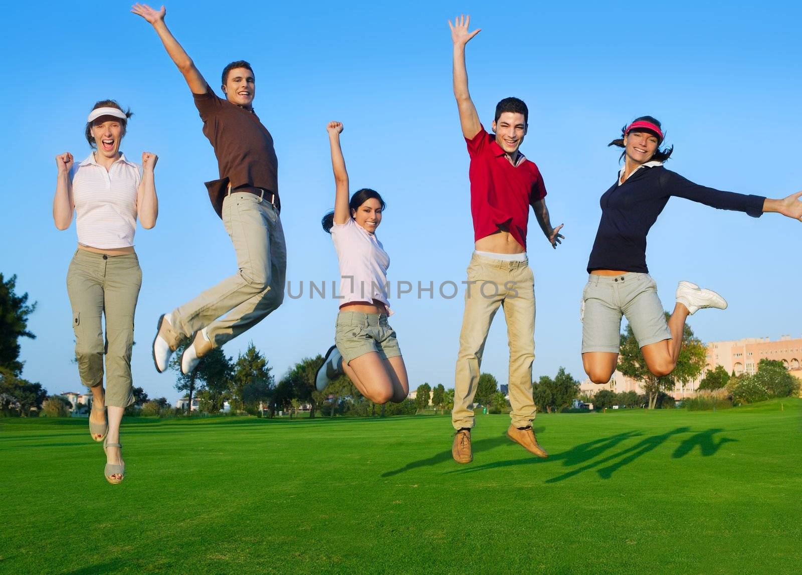 happy jump group of young people jumping outdoors grass