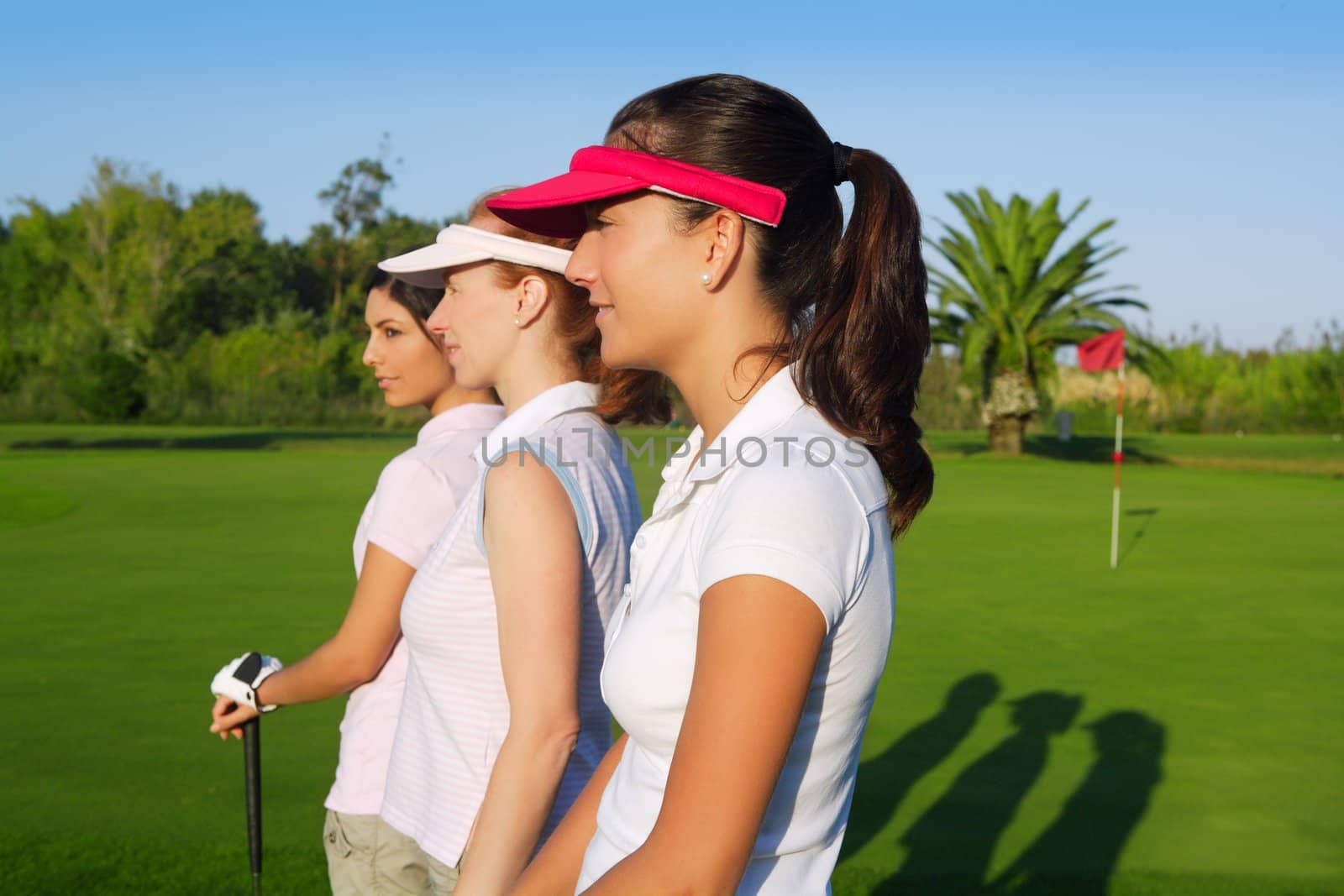Golf three woman in a row green grass course by lunamarina