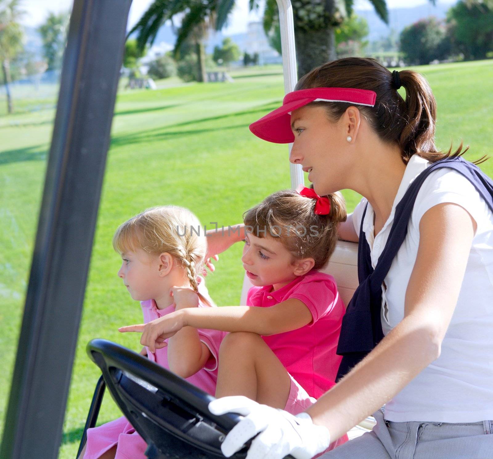 golf course family mother and daughters in buggy green grass field