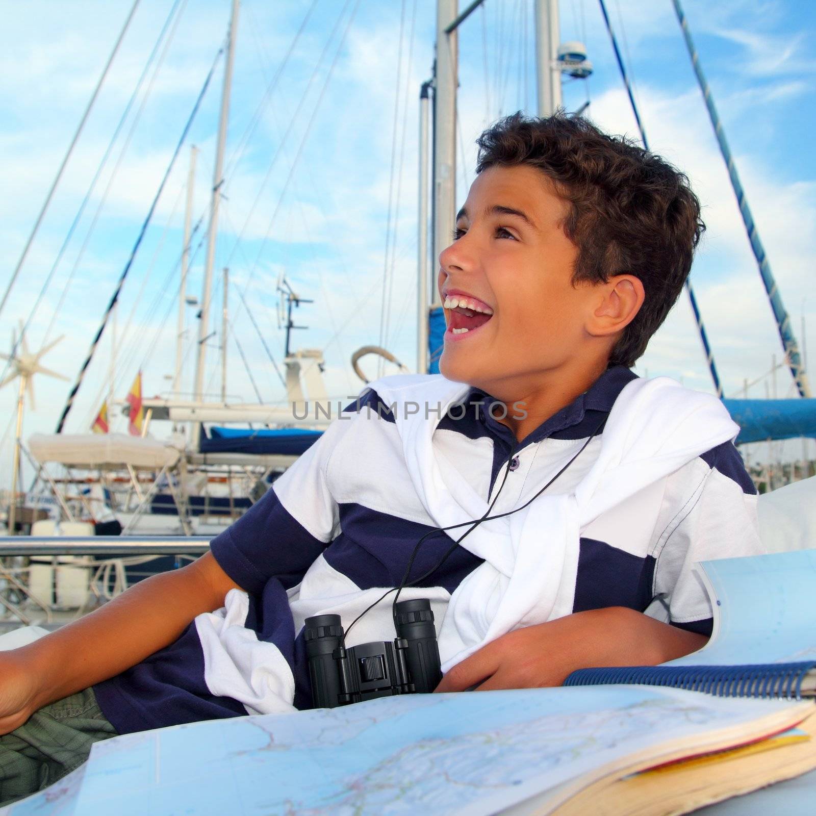boy teen sailor laying on marina boat chart map smiling in summer vacation