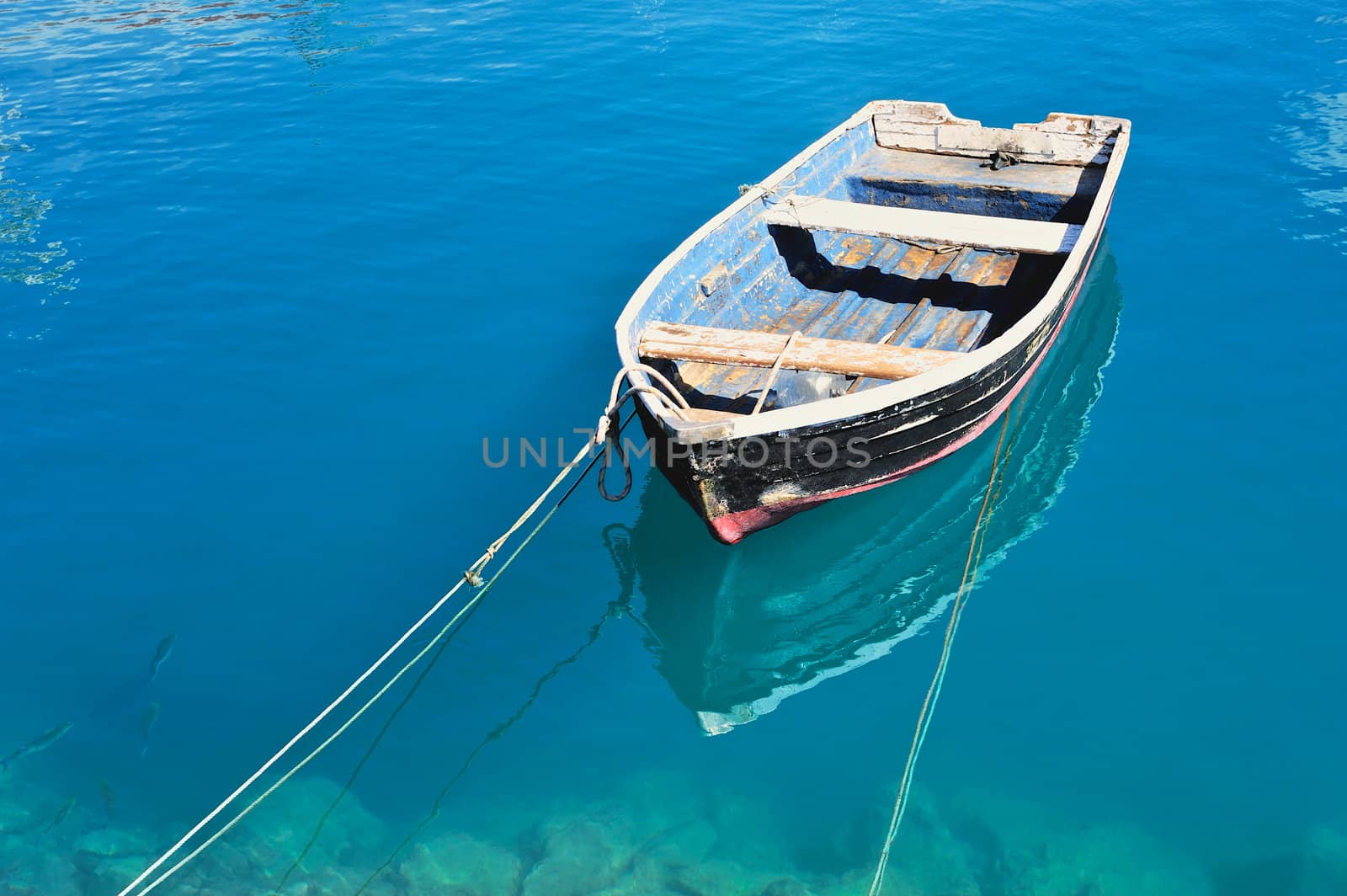 Old fishing boat on the transparent water surface