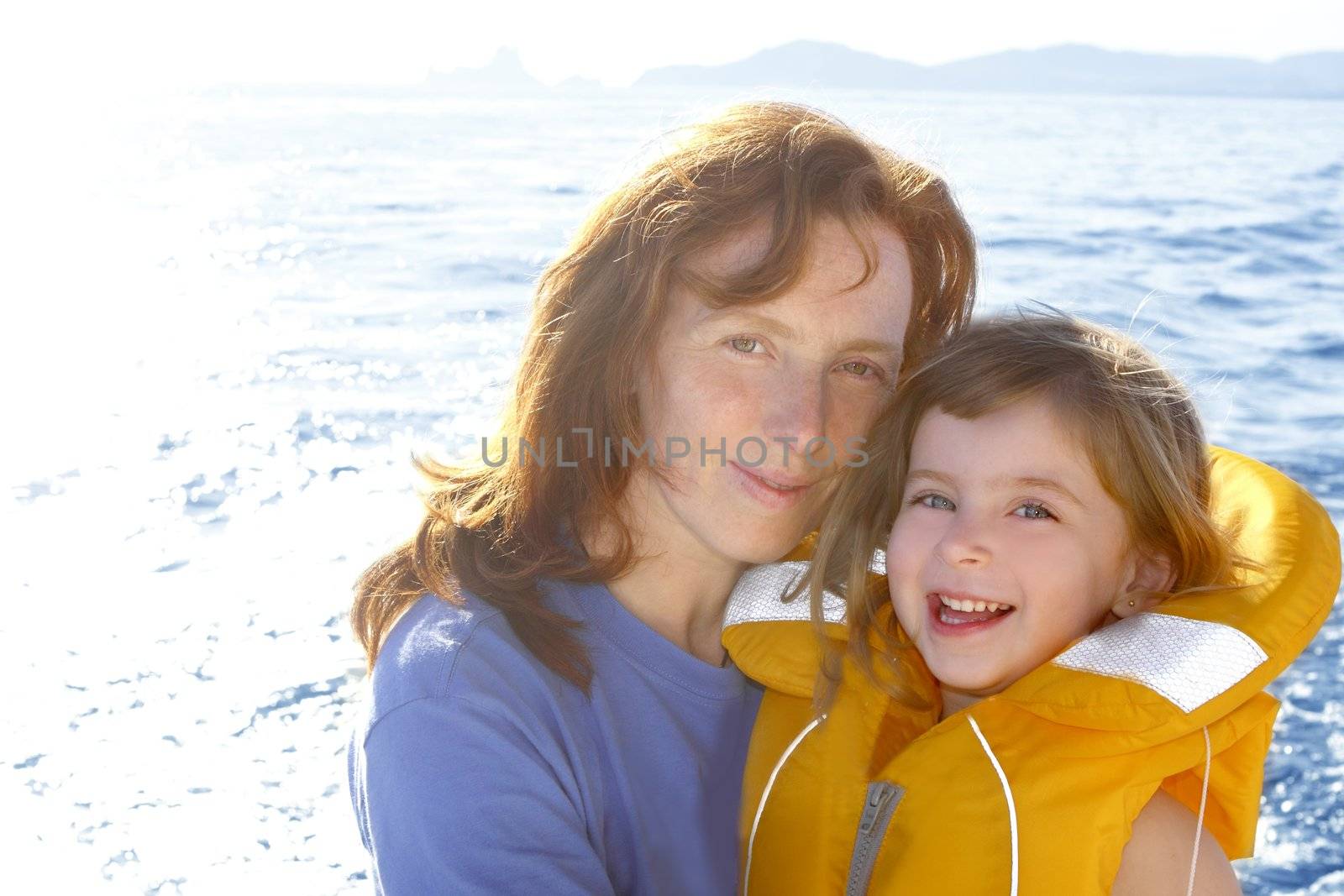 mother and daughter safety vest backlight sea smiling