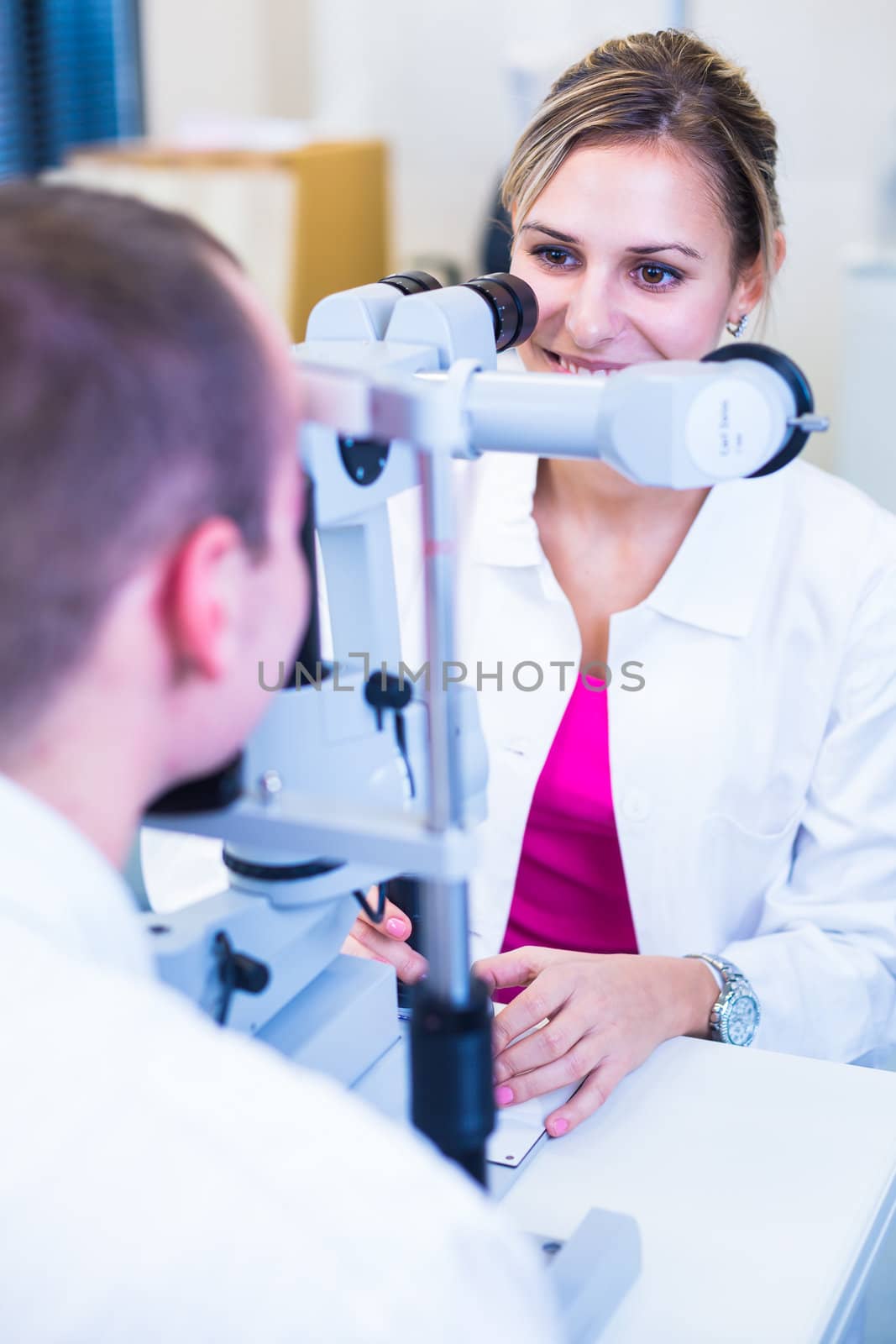 Optometry concept - handsome young man having his eyes examined  by viktor_cap