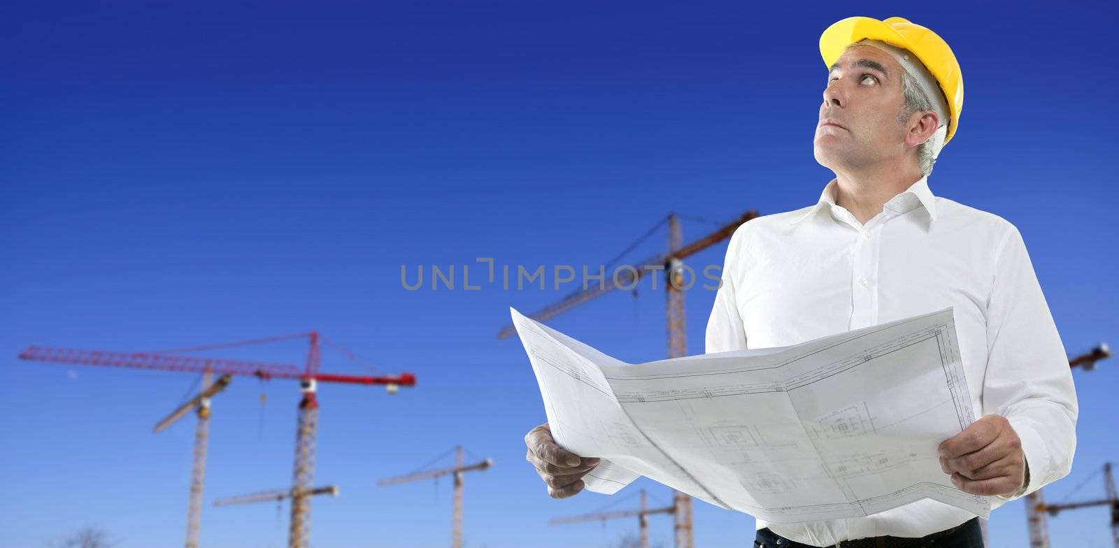 architect engineer plan construction cranes blue sky yellow hardhat