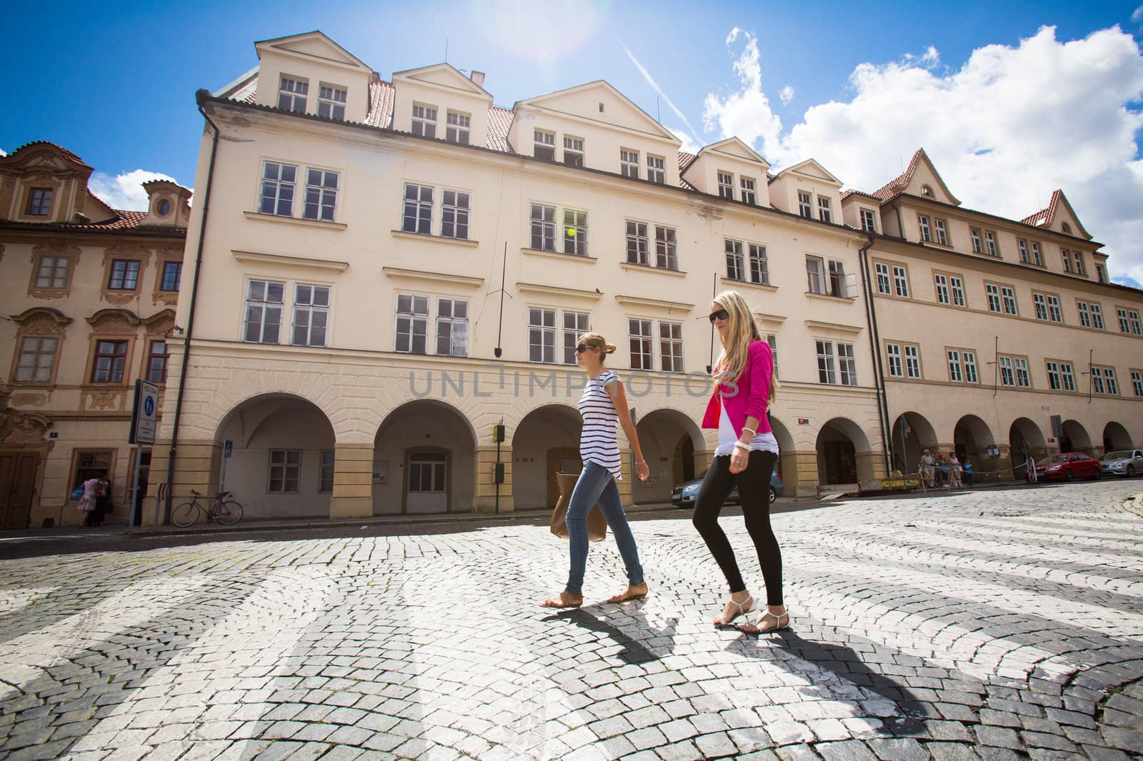 Two pretty, young women walking in the Prague historic center