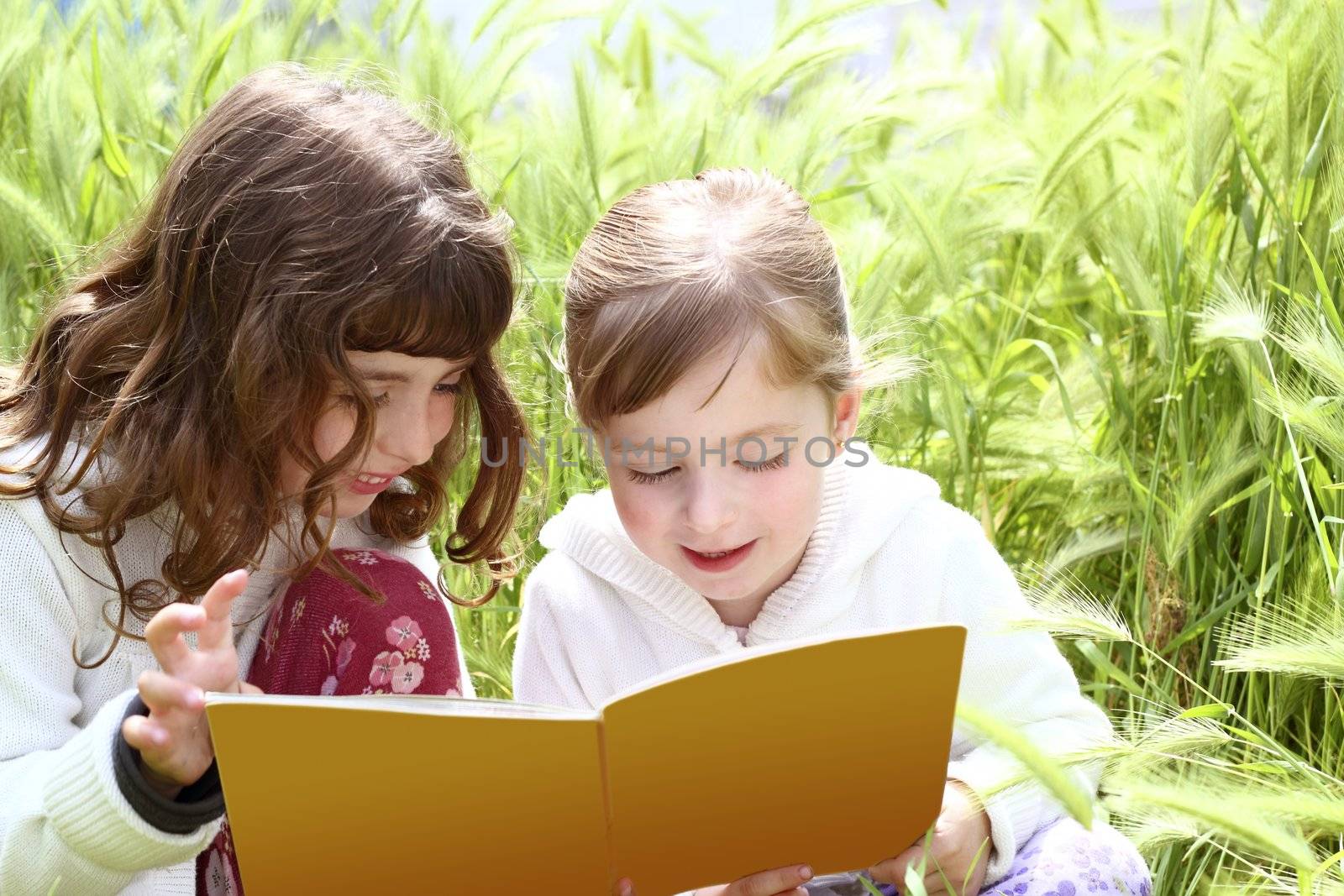 two little sister girls reading book spikes garden