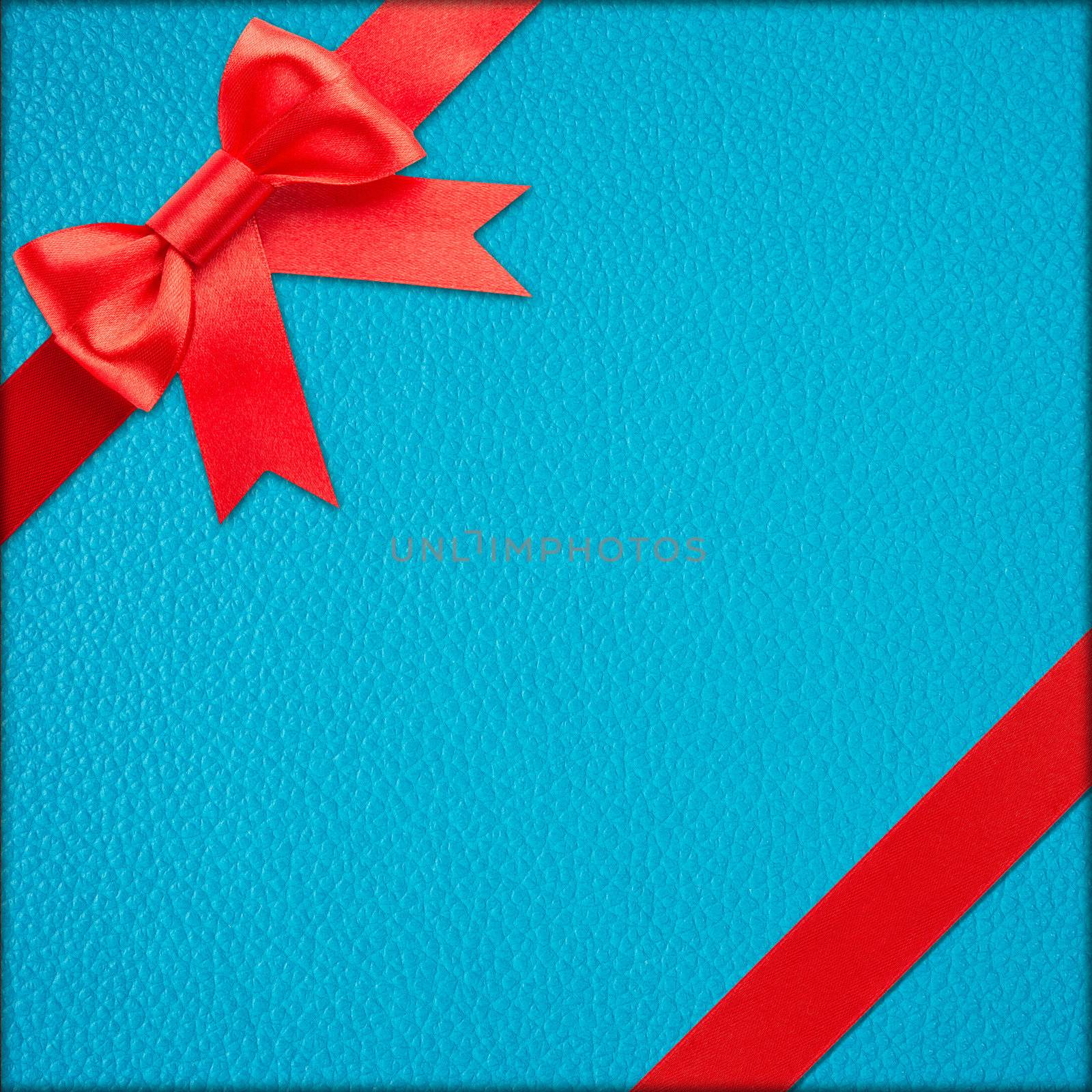 Red bow and ribbon over blue wrapped gift