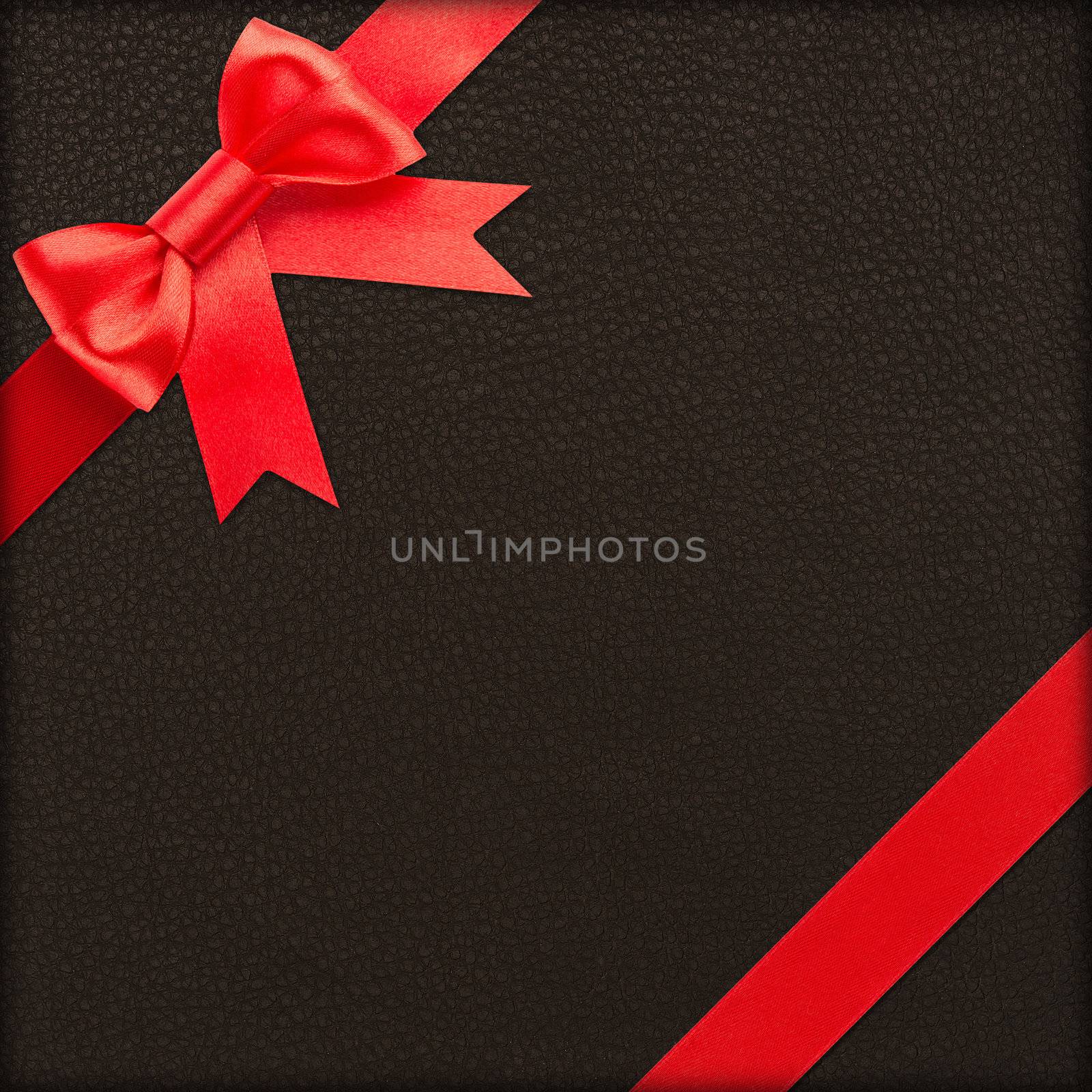 Red bow and ribbon over brown wrapped gift