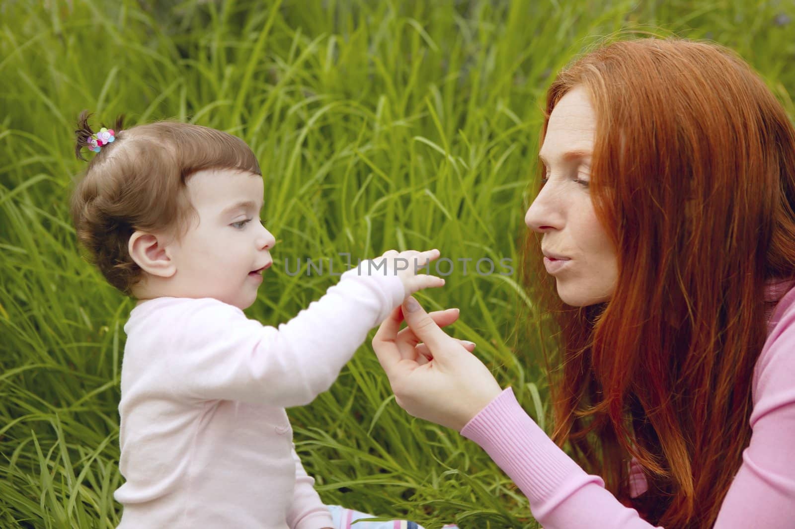 baby and redhead mother outdoor grass playing park together