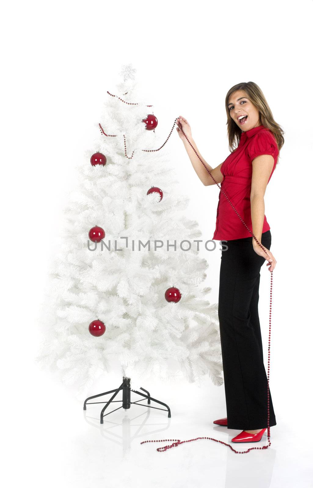 Beautiful attractive woman posing near a white Cristmas tree