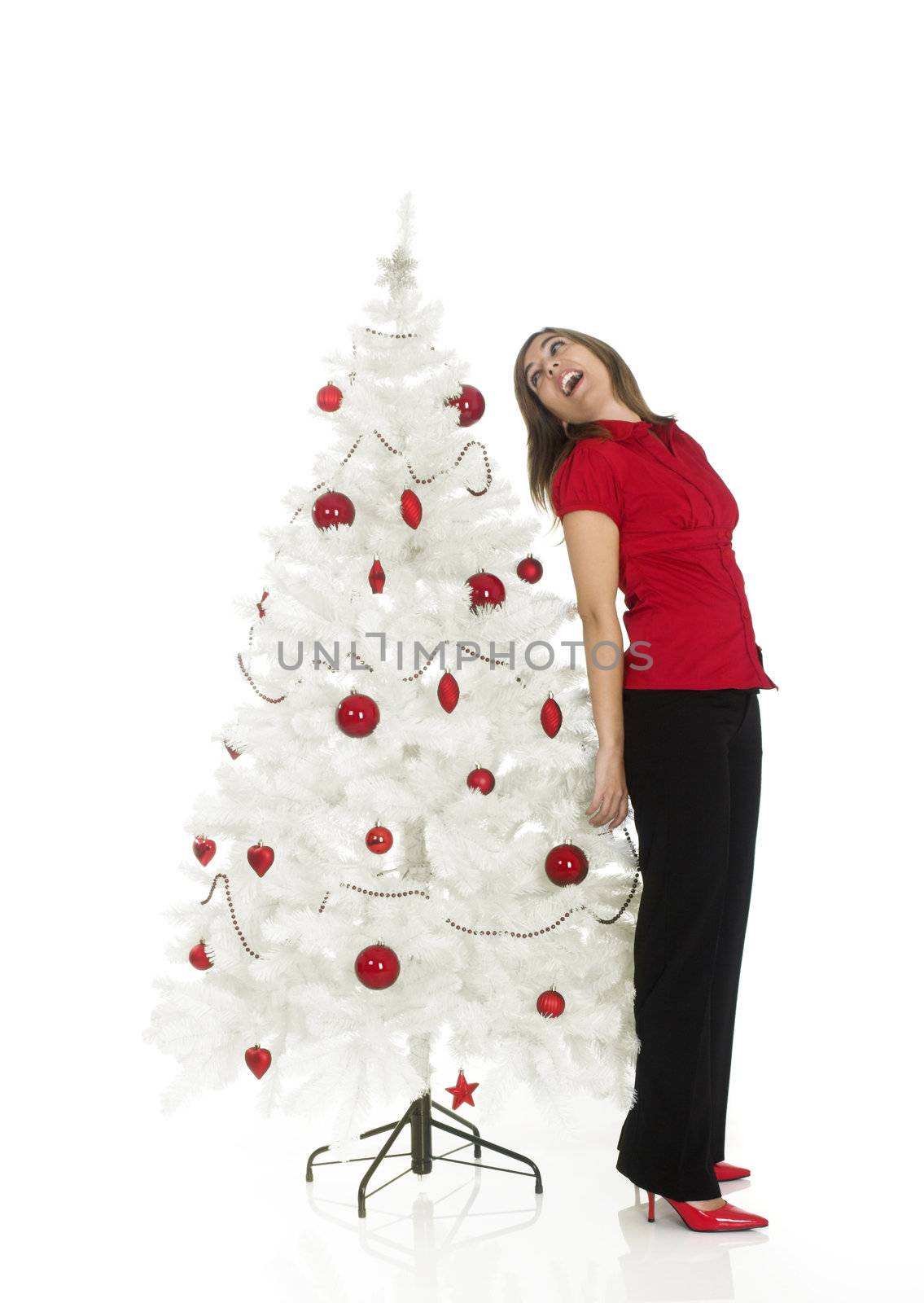 Beautiful attractive woman posing near a white Christmas tree