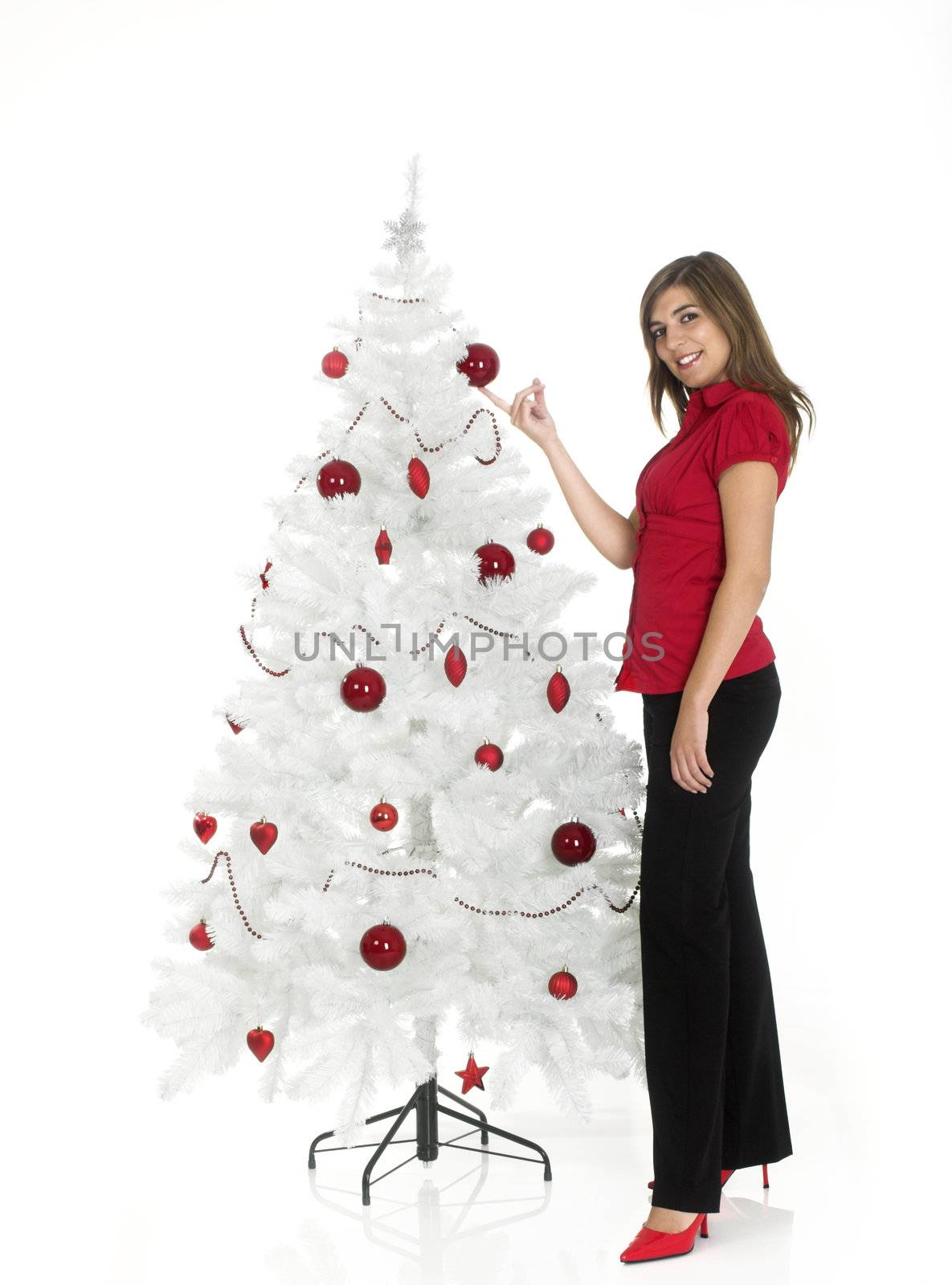 Beautiful attractive woman posing near a white Cristmas tree