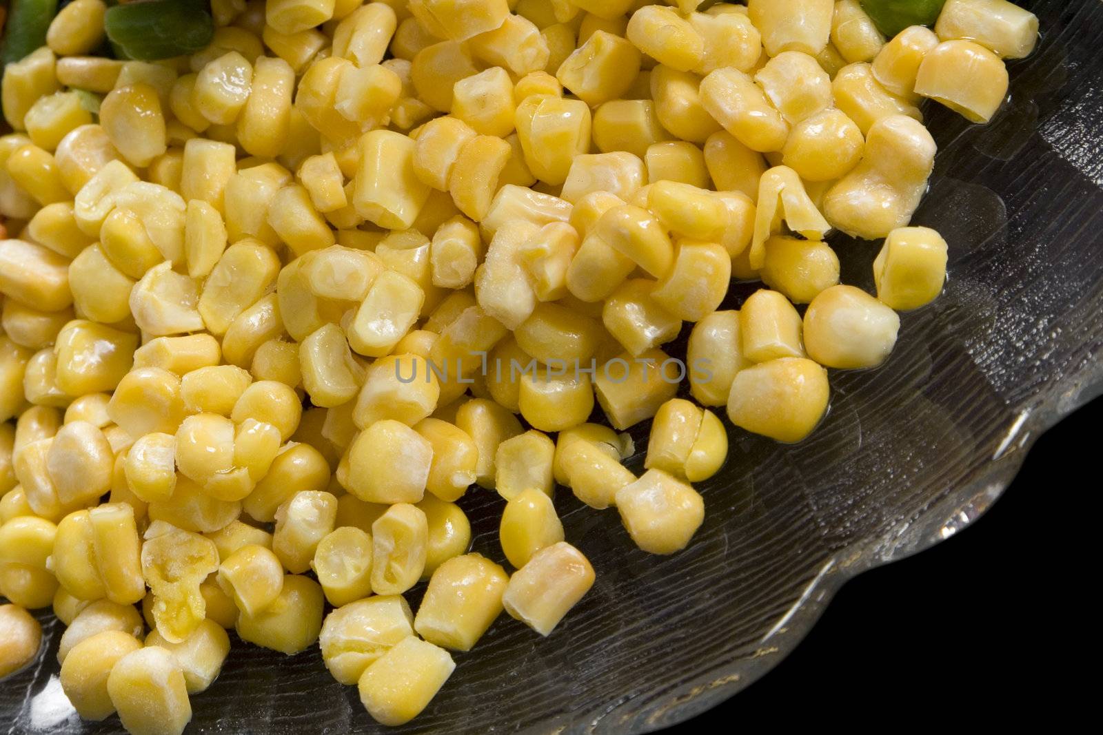 Precooked corn on a glass dish on a black background