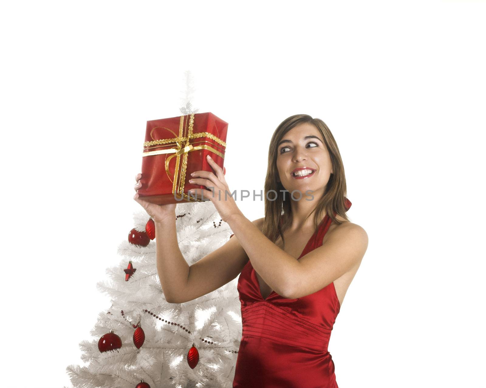 Beautiful happy woman near a white Christmas tree holding Christmas presents