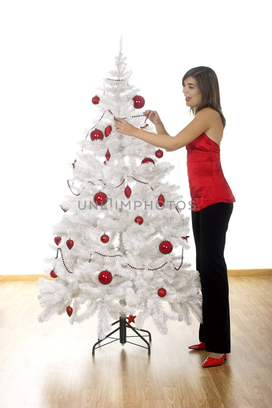 Beautiful attractive woman posing near a white Christmas tree