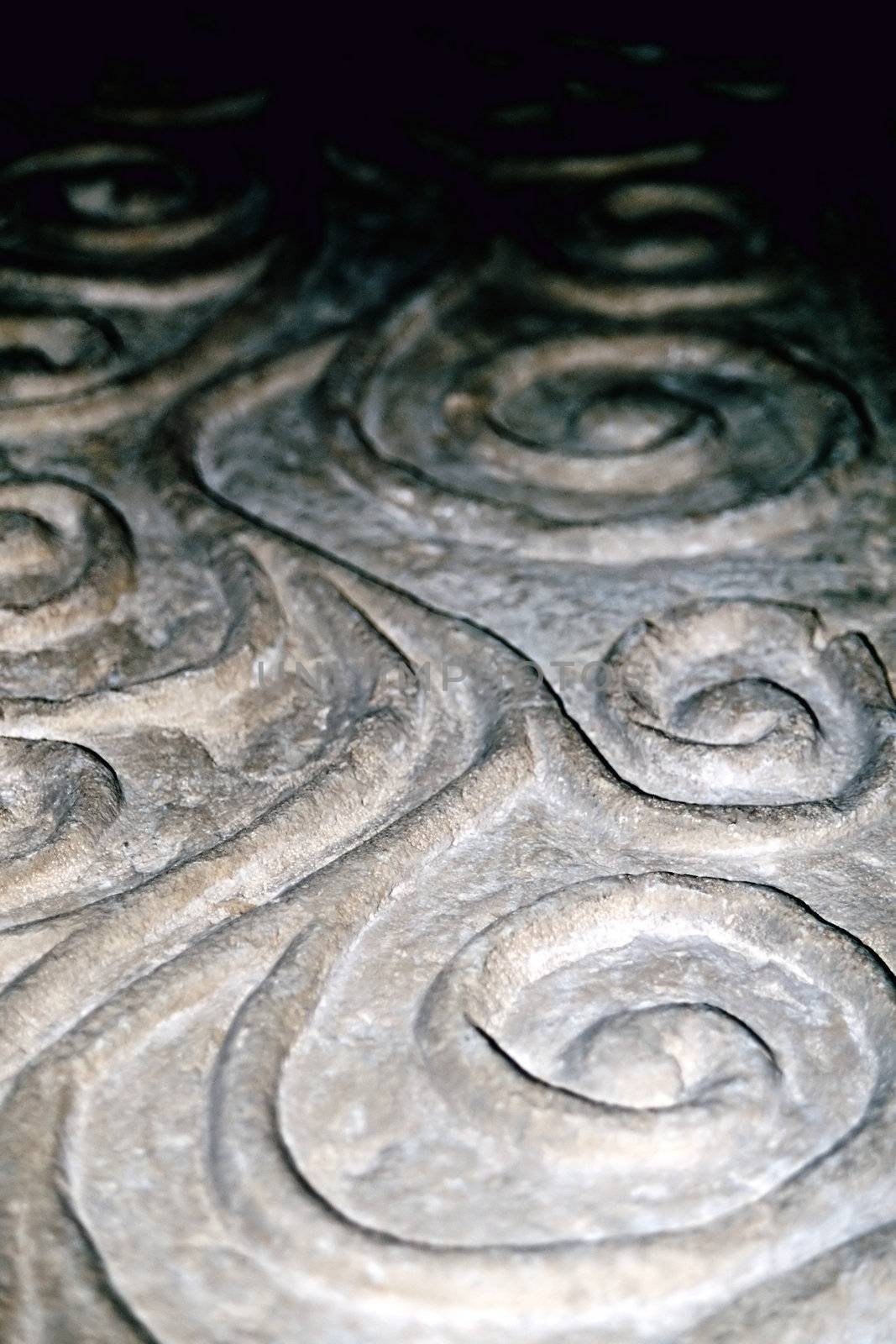 detail of old stone carving on a english baptism font