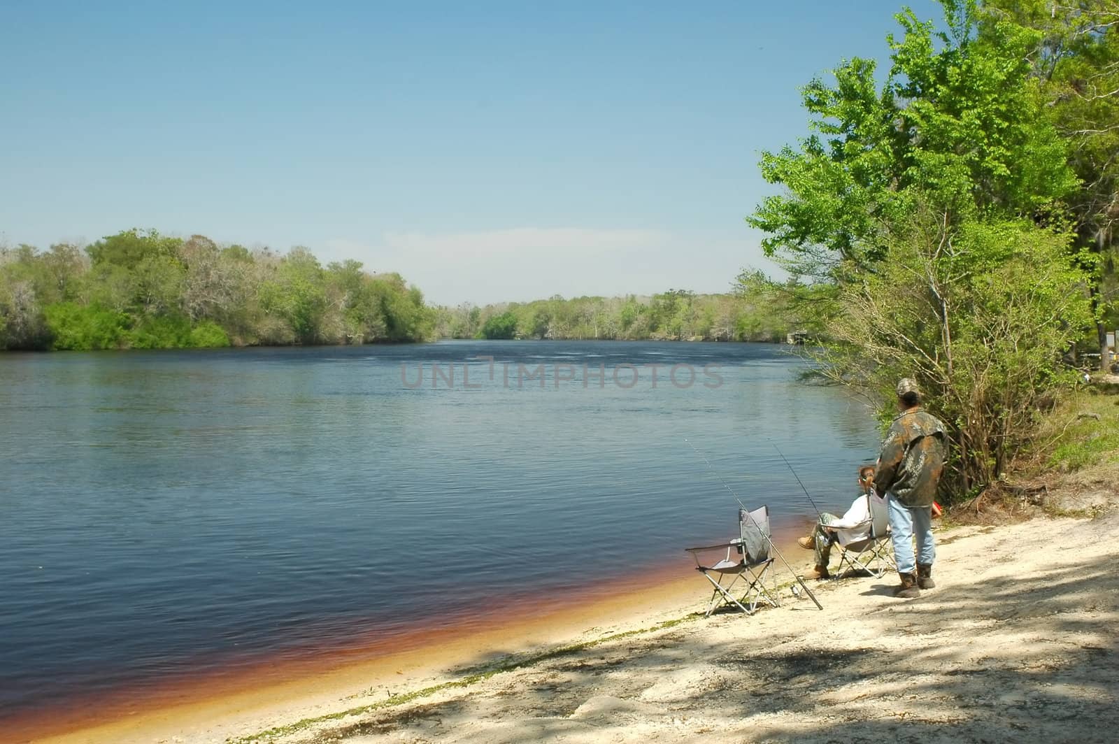 A family relaxes while fishing on the shore of the Suwannee River near Manatee Springs, Florida.